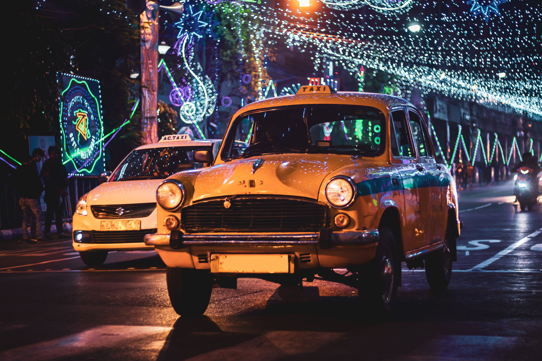 a yellow taxi driving down a street filled with traffic