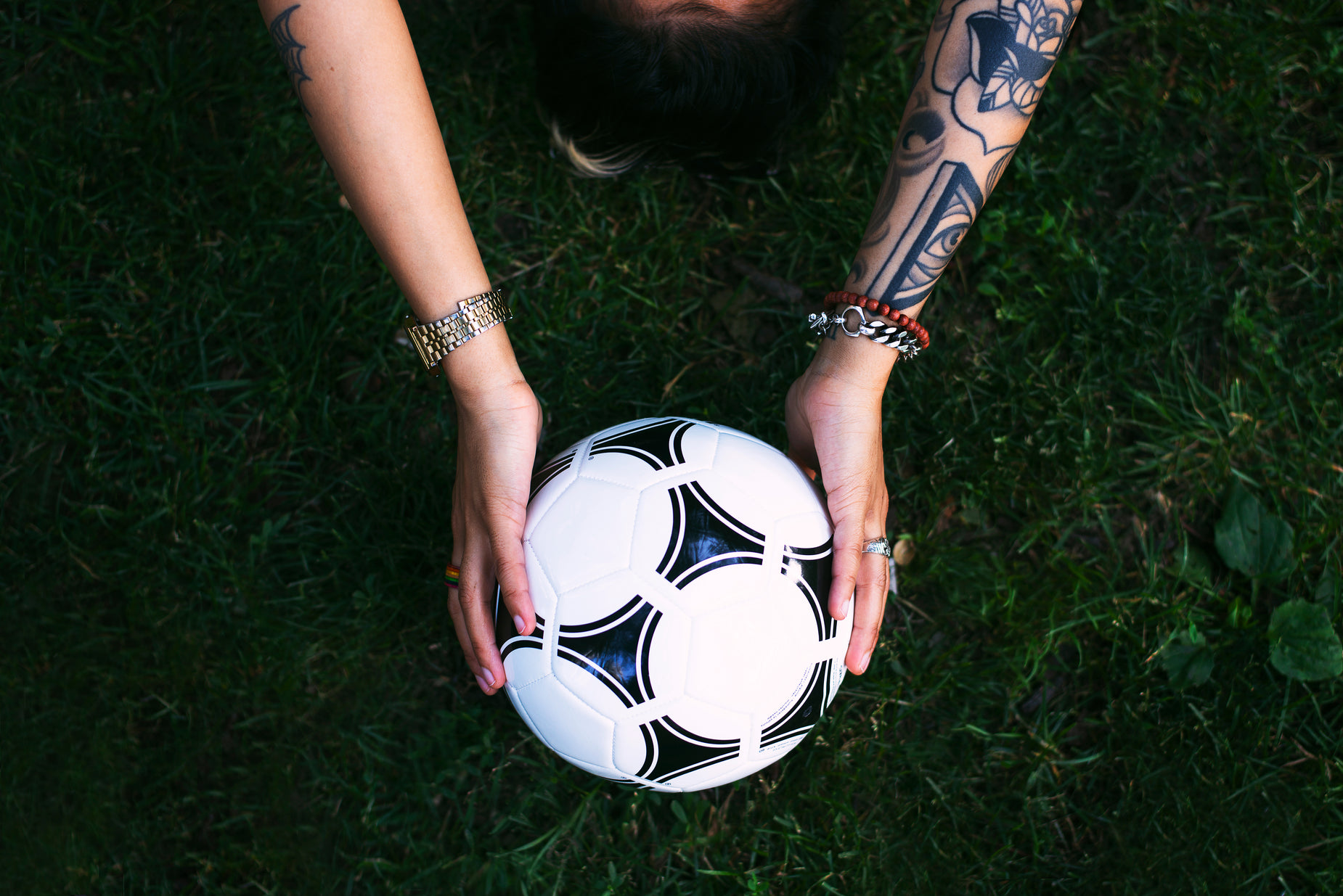 the tattooed man is holding a white and black soccer ball