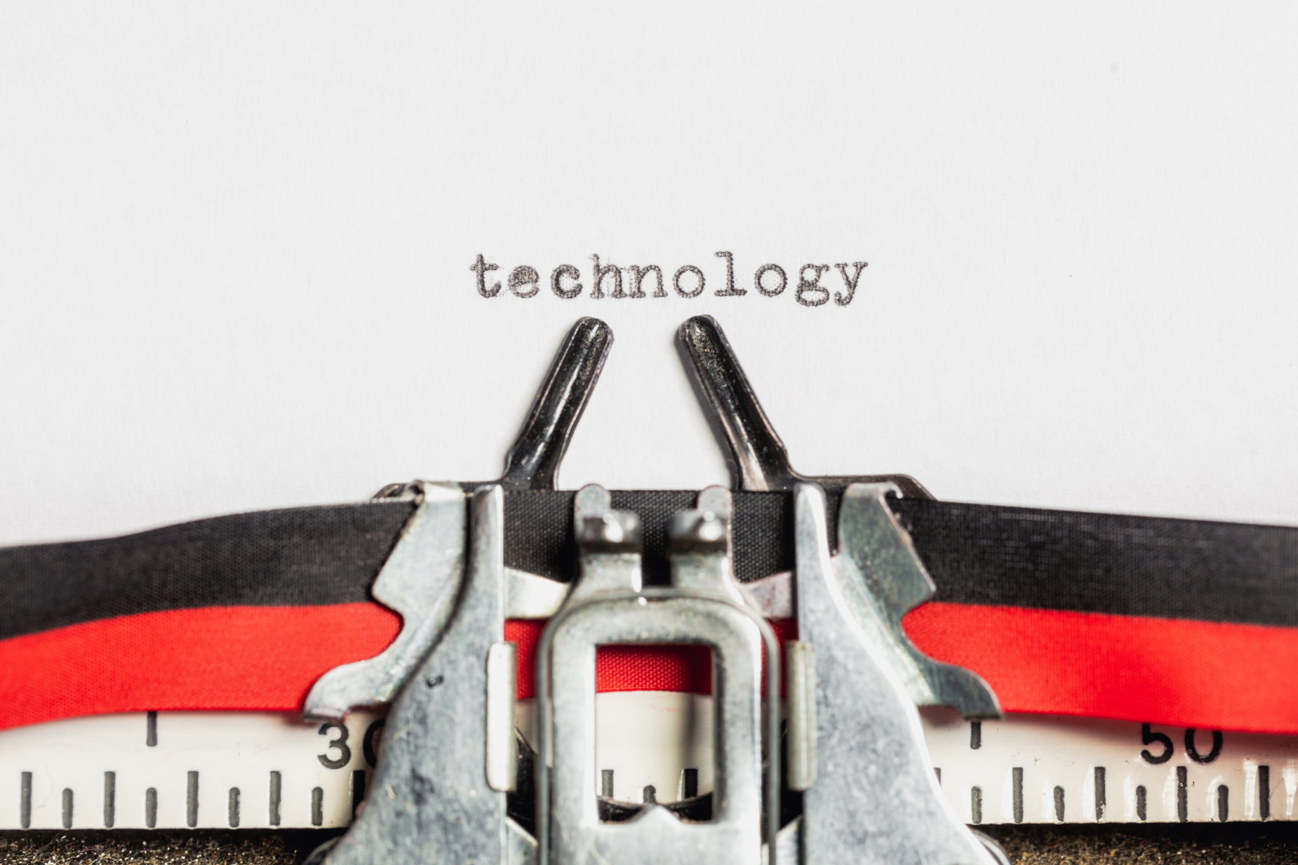 a closeup view of a typewriter with the word technology and two pairs of metal clamps