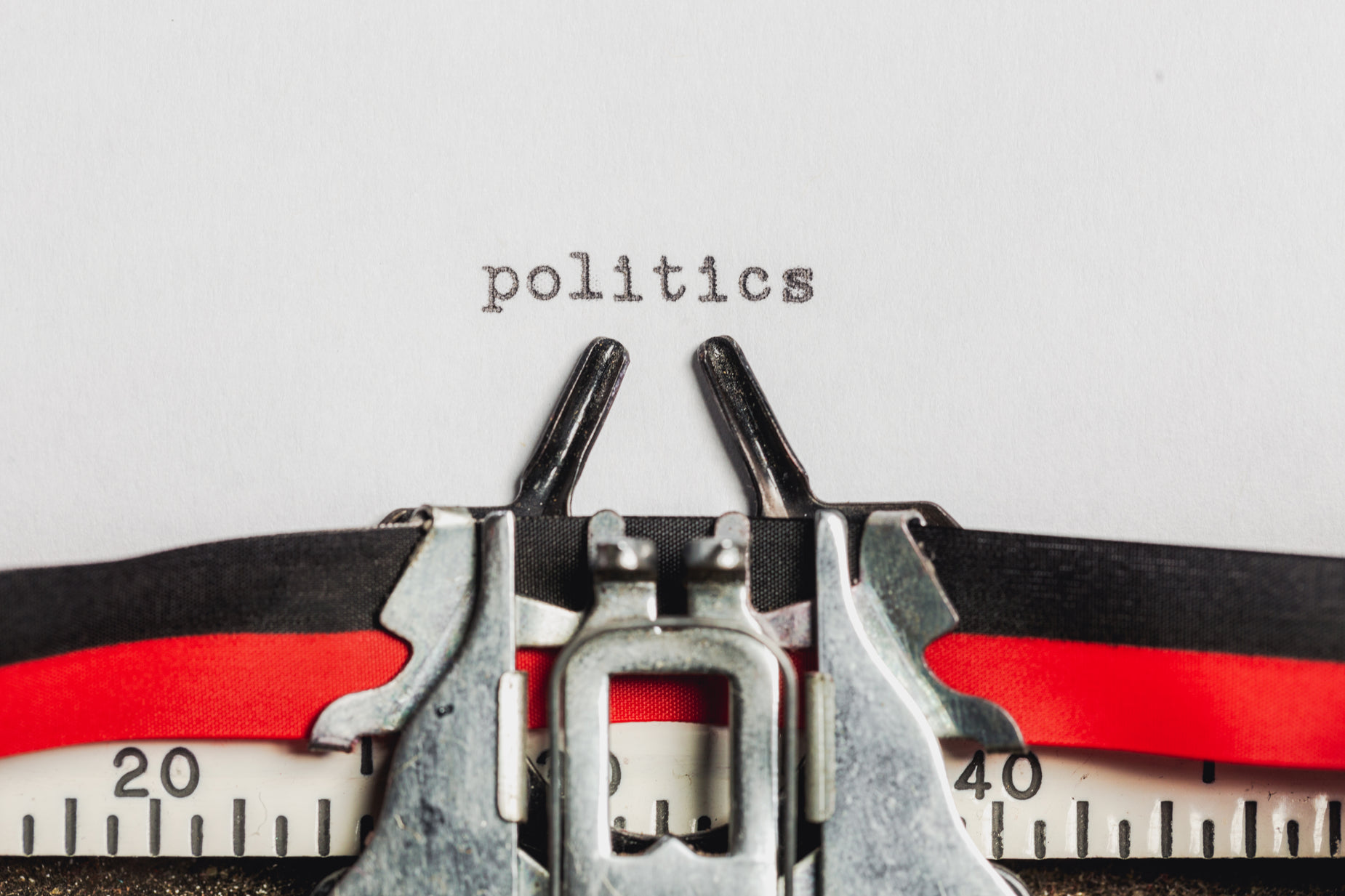 two scissors are next to a typewriter that says politics
