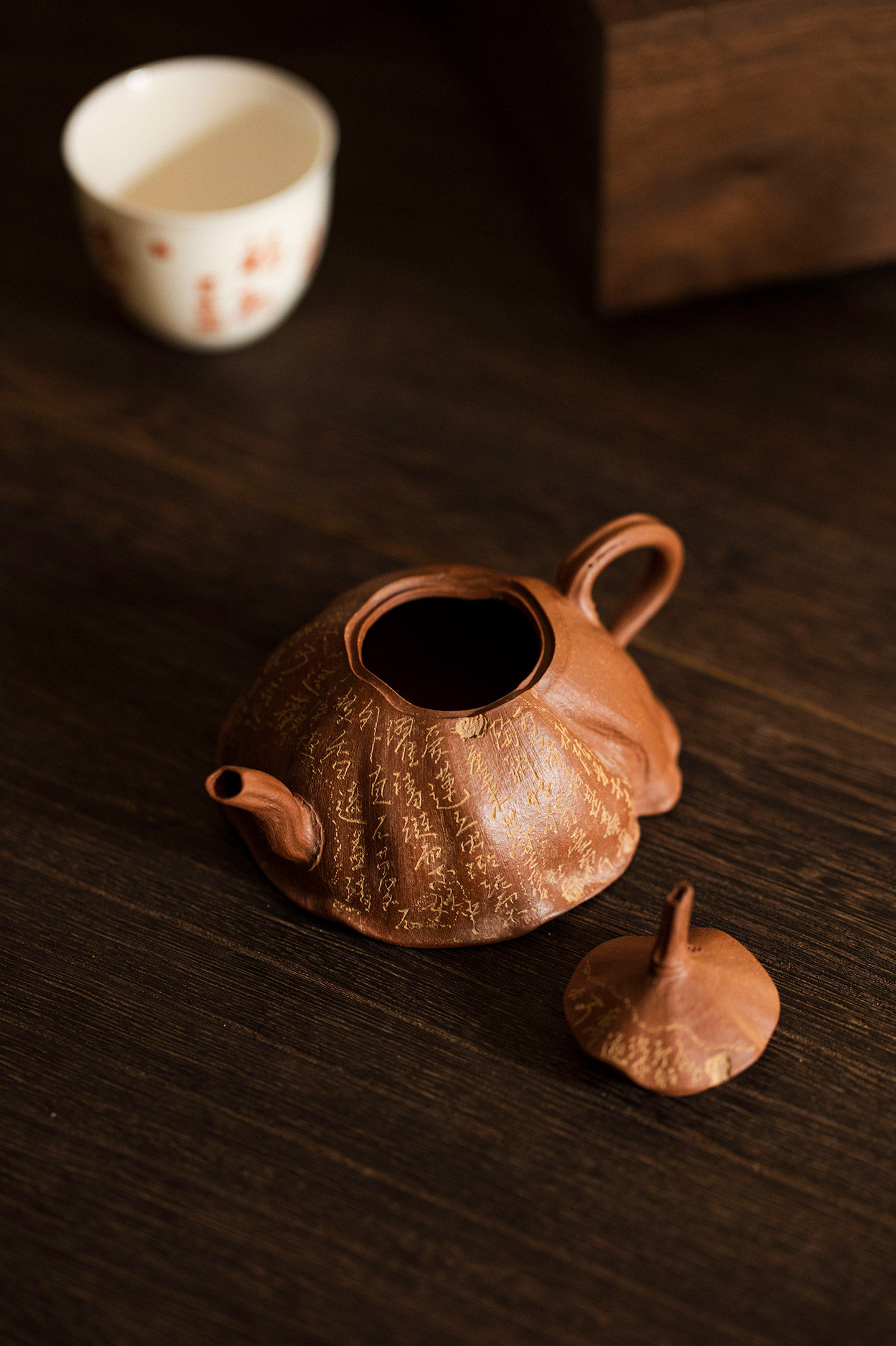 a wooden teapot and two cups on a table