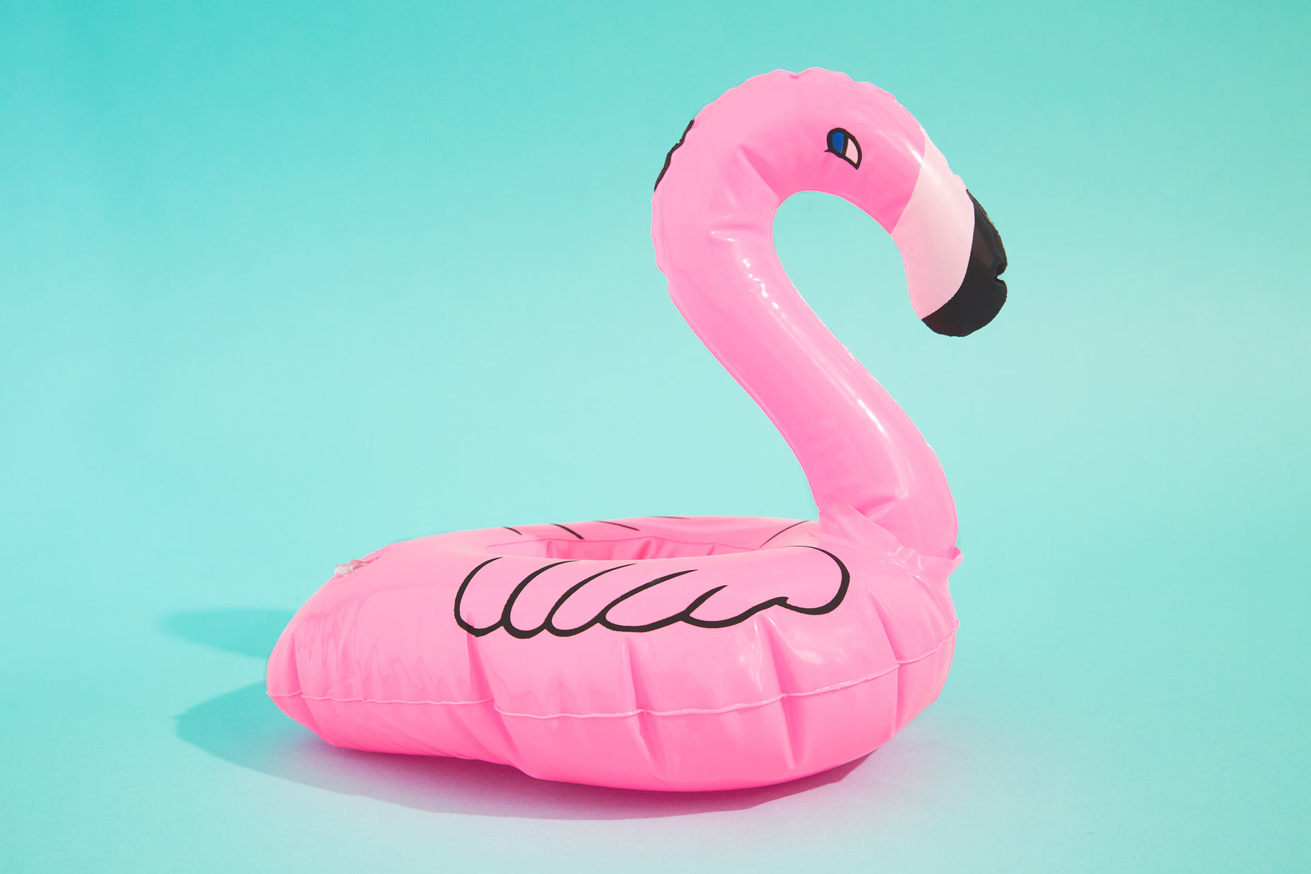 pink flamingo swimming in the air on turquoise background