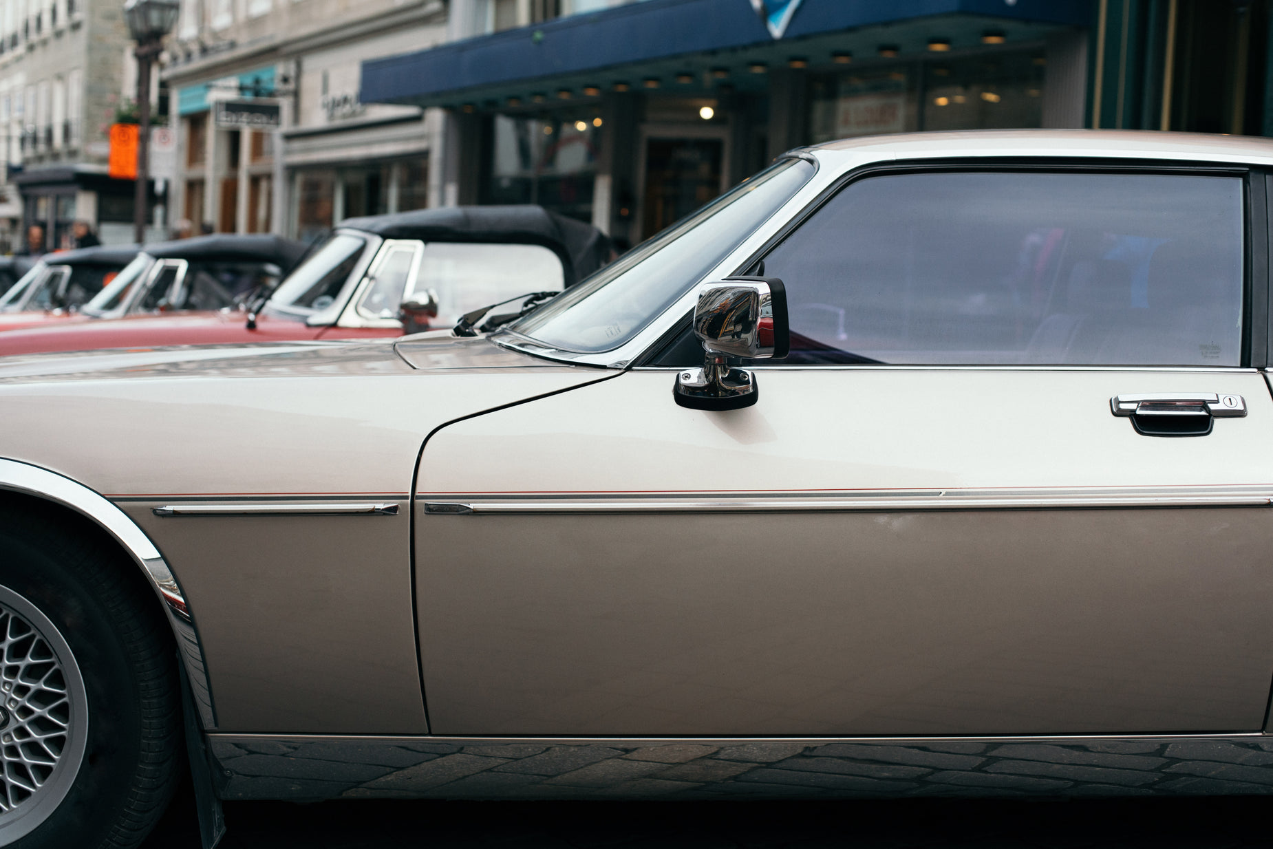 vintage cars parked in a line along the street