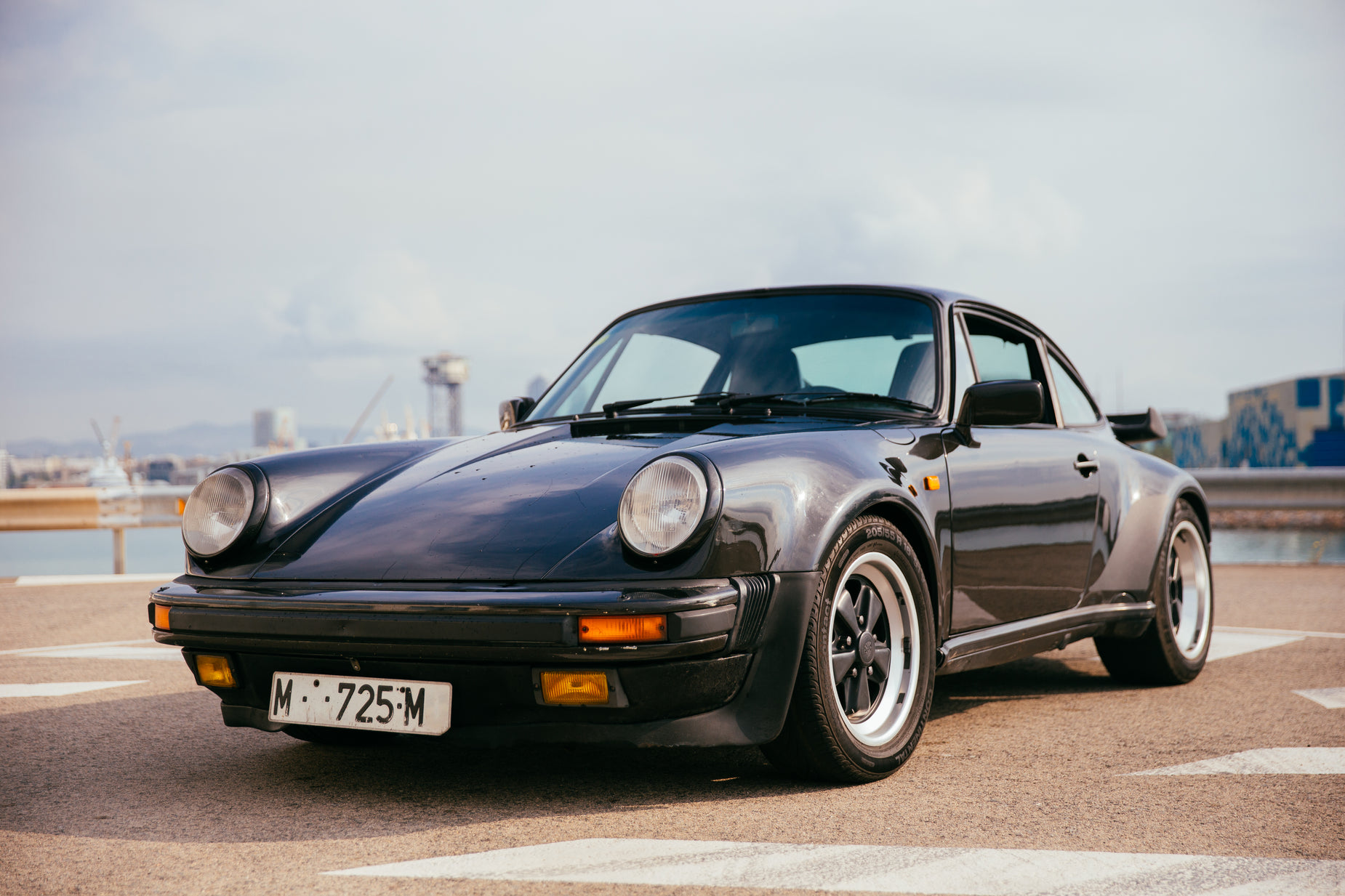 an old black sports car in a parking lot