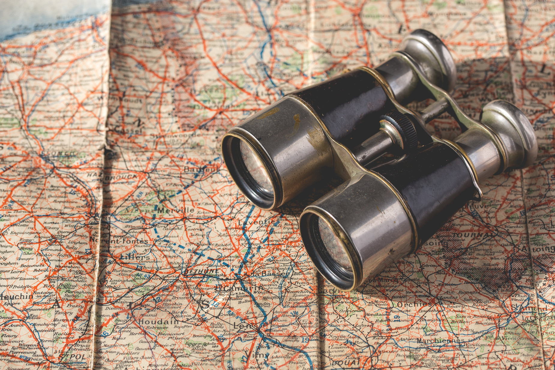 two binoculars are positioned on a map as if they are looking for directions