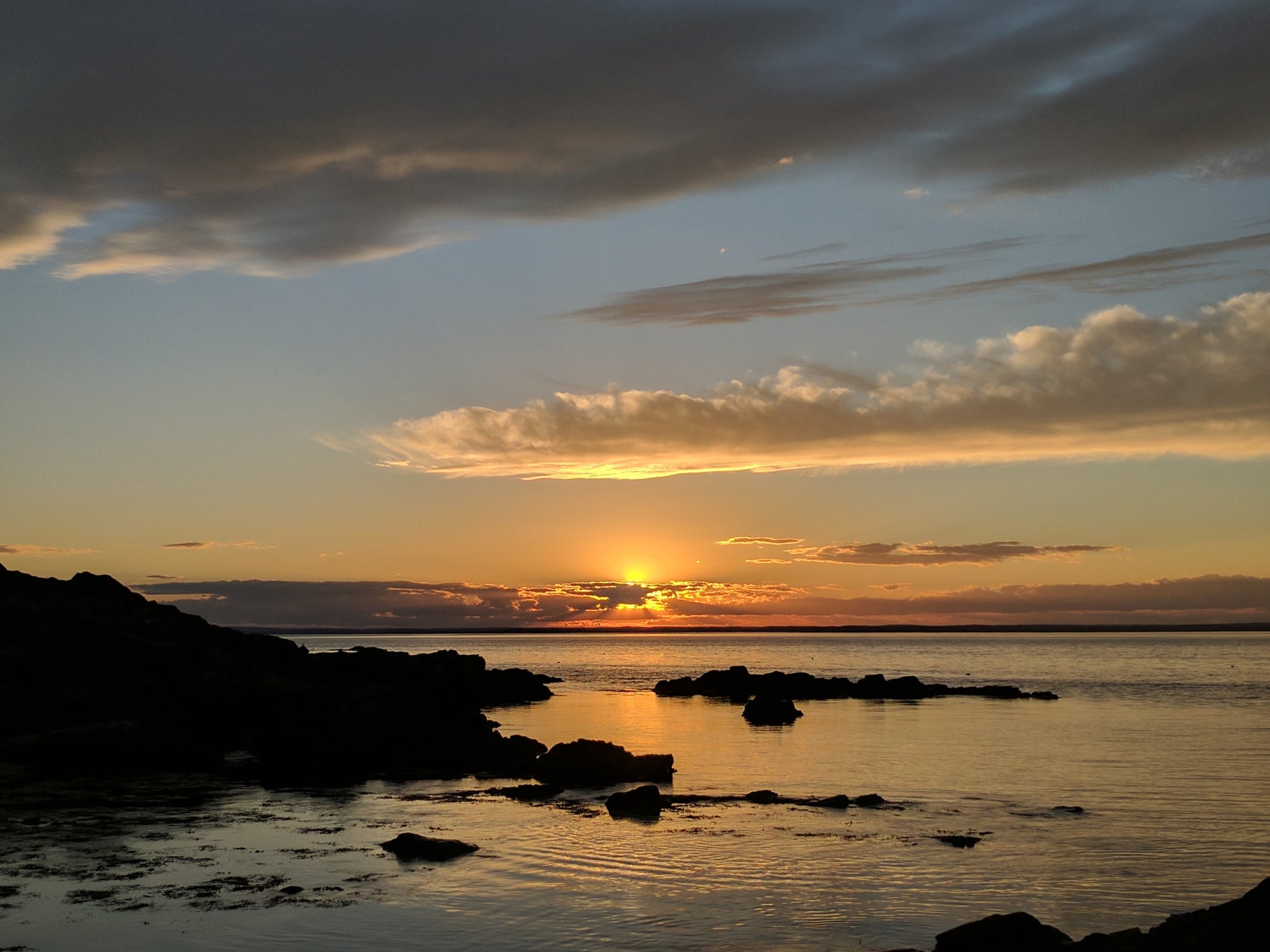 the sun setting over the ocean with some water