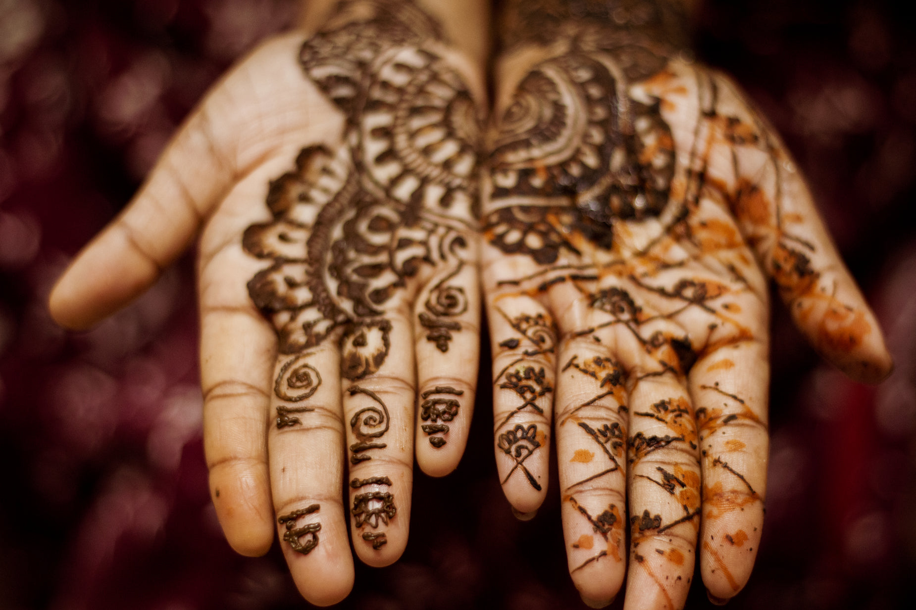 a henna - painted hand holding soing that looks like erflies