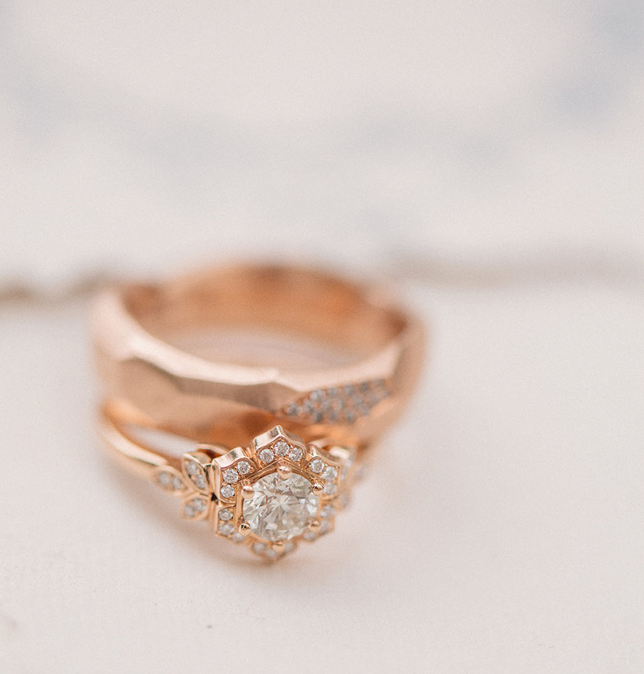 three gold wedding rings and engagement ring bands on a table