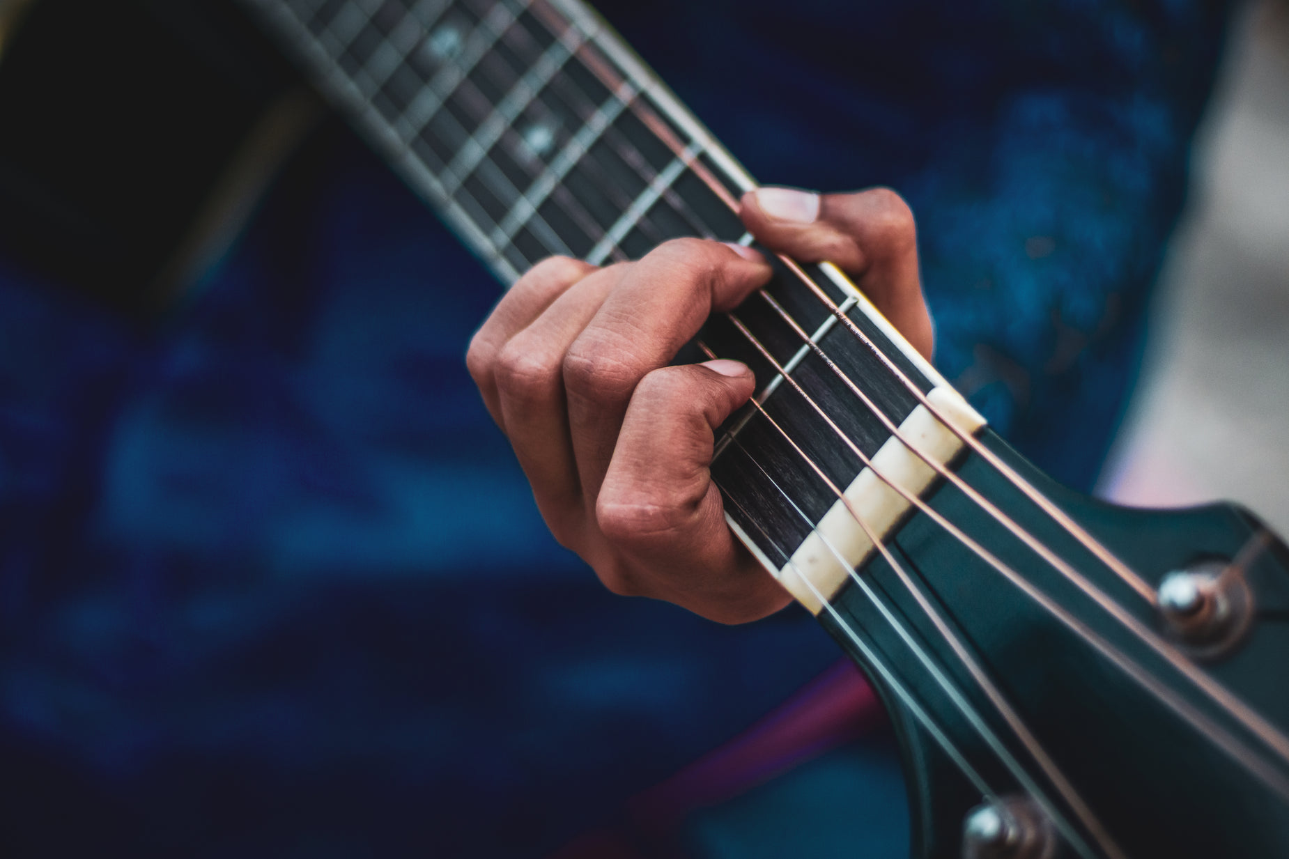 a close - up view of a person's hands playing an electric guitar