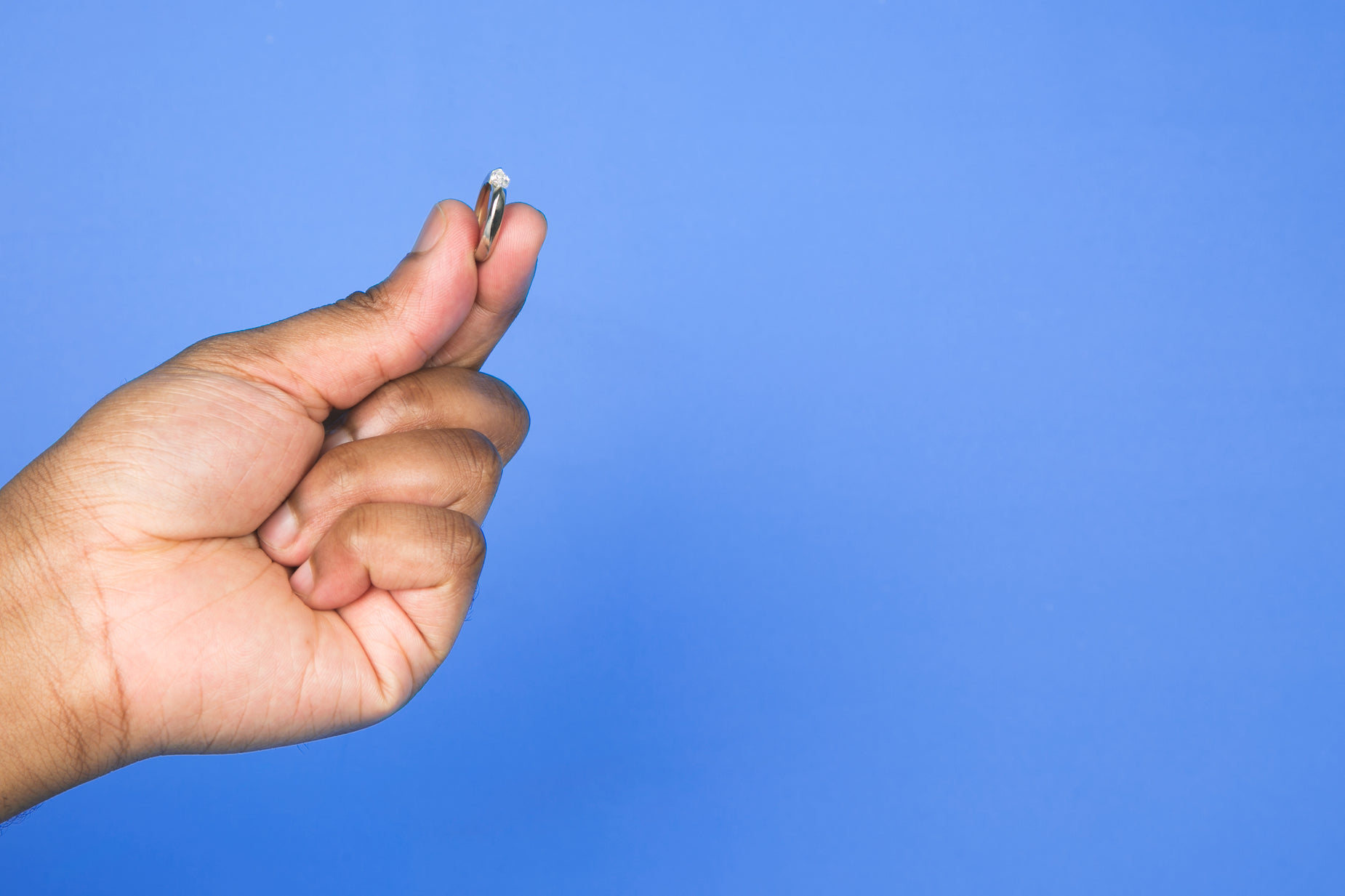 someone's hand is holding an empty tiny pill bottle