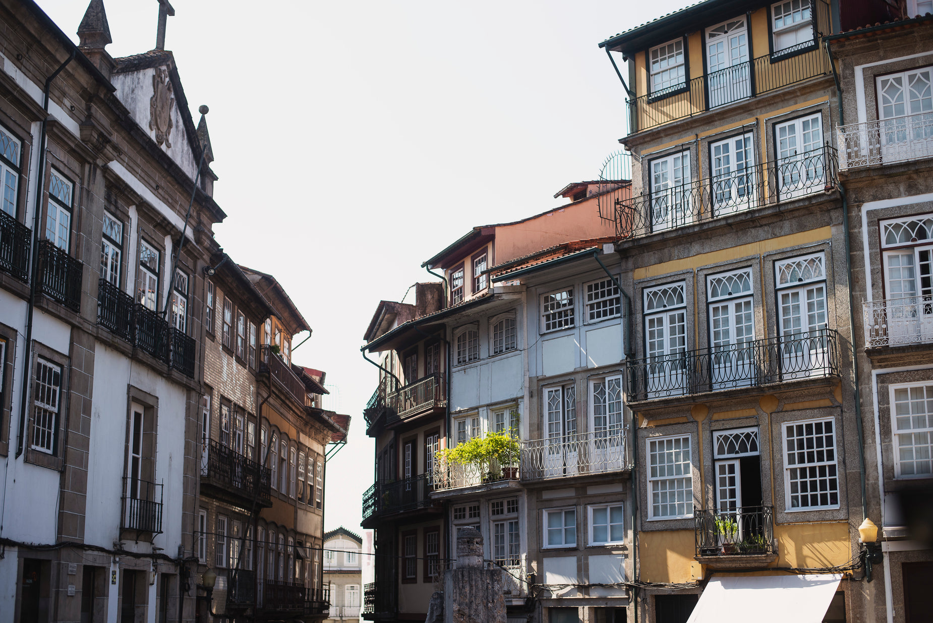 a narrow street lined with multiple old buildings