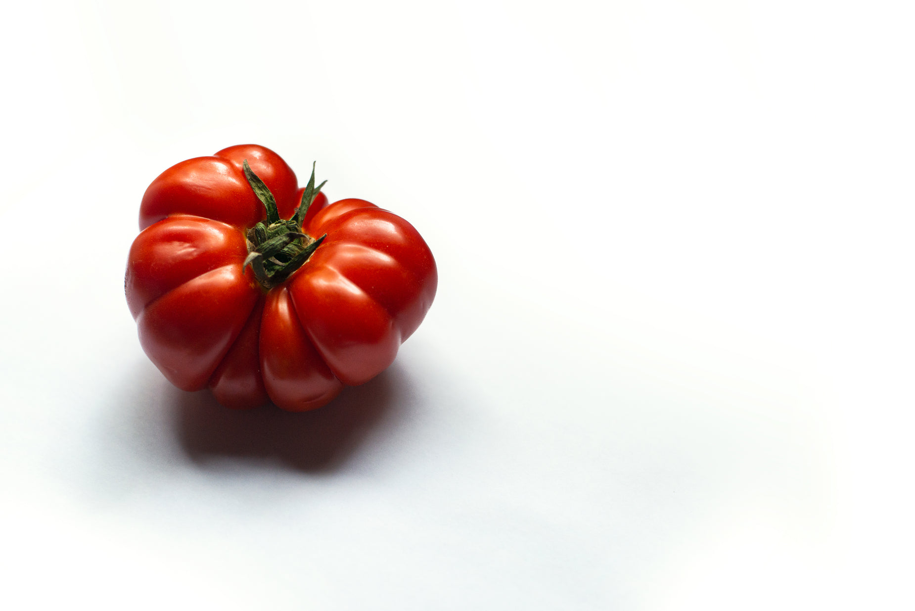 a cluster of red tomatoes placed together on a white background