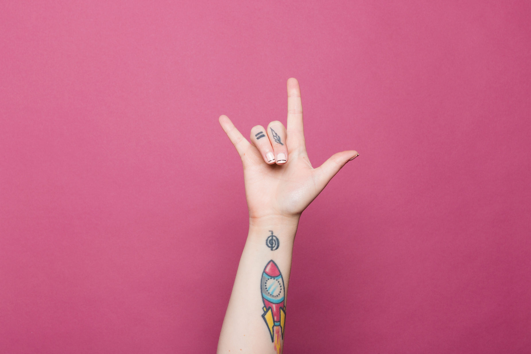 a hand with tattoos is gesturing towards soing