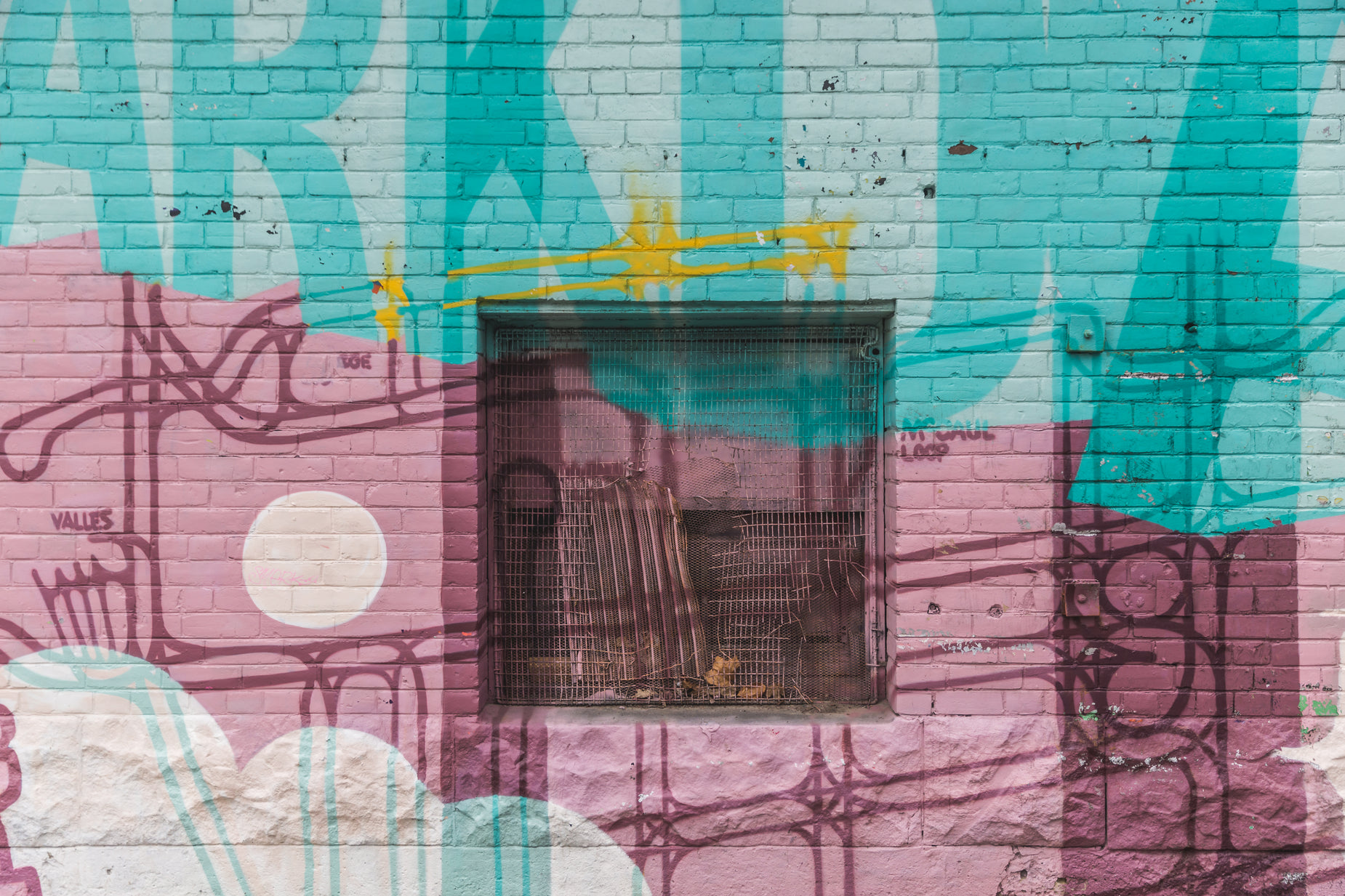 a blue, pink, and yellow brick wall with the window drawn
