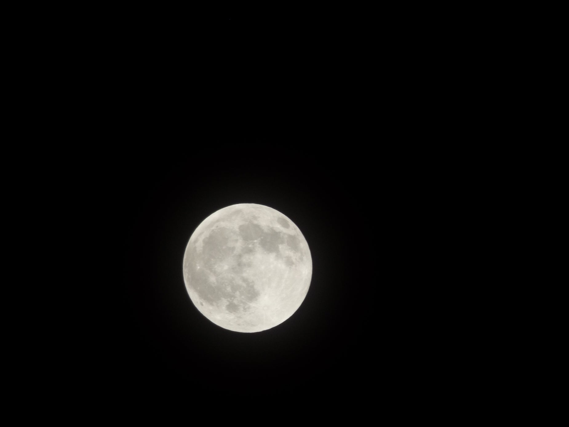 an airplane flying low in the sky over a full moon