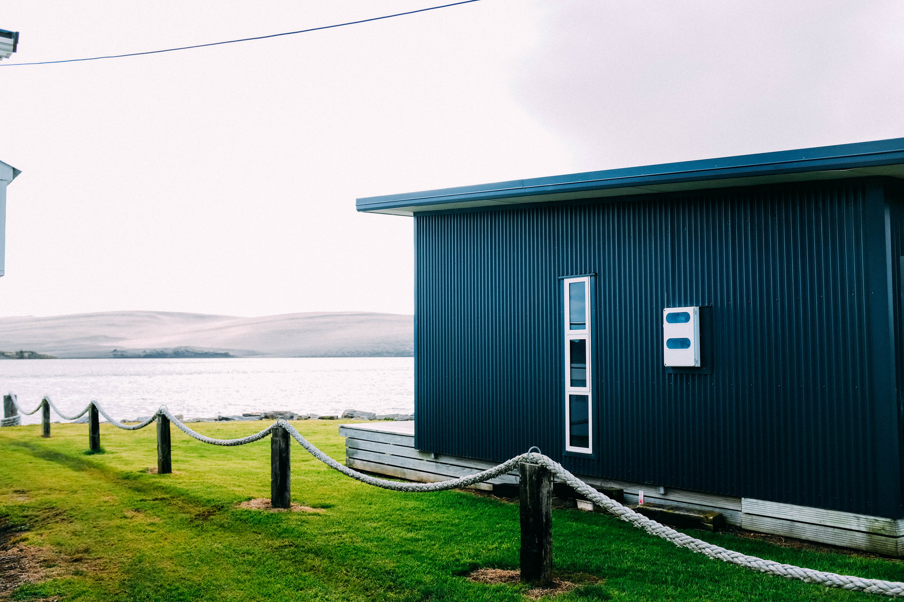 a small house with the door closed on the grass