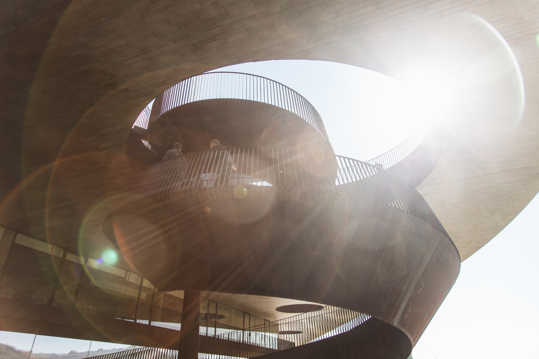 a sun shines through an iron spiral