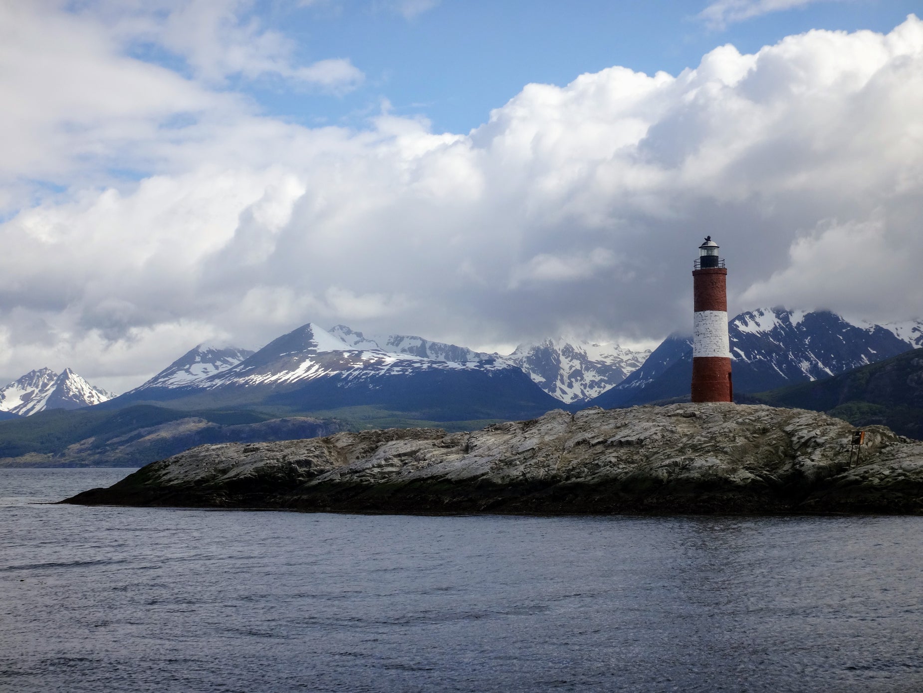 a lighthouse is shown with a mountain range in the background