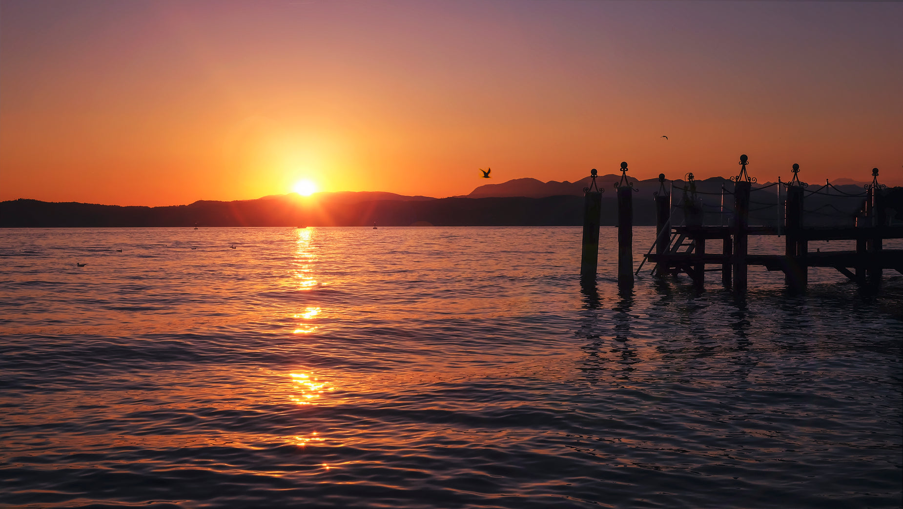 the sun is setting in the distance over a body of water