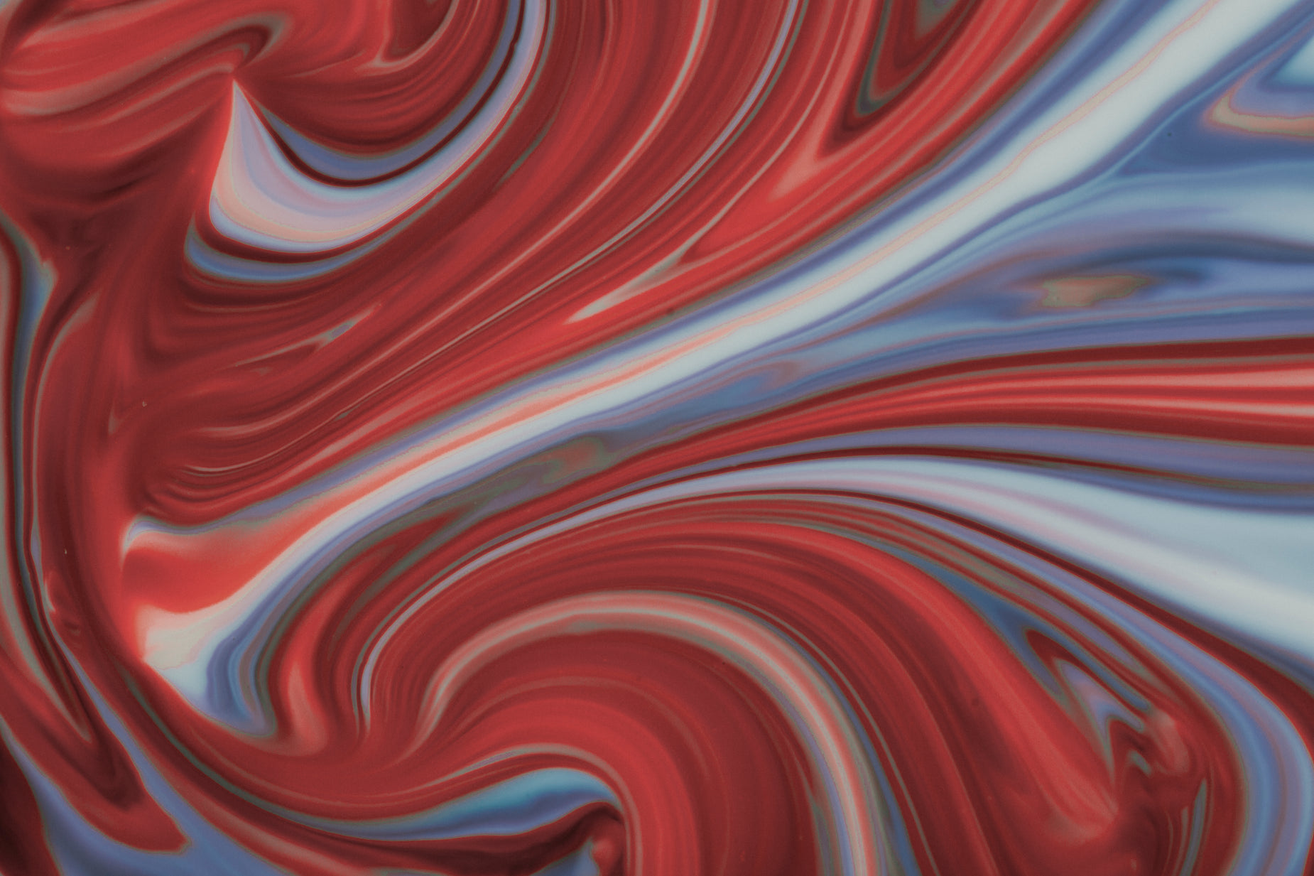 colorful fluid paint mixing over red and blue material