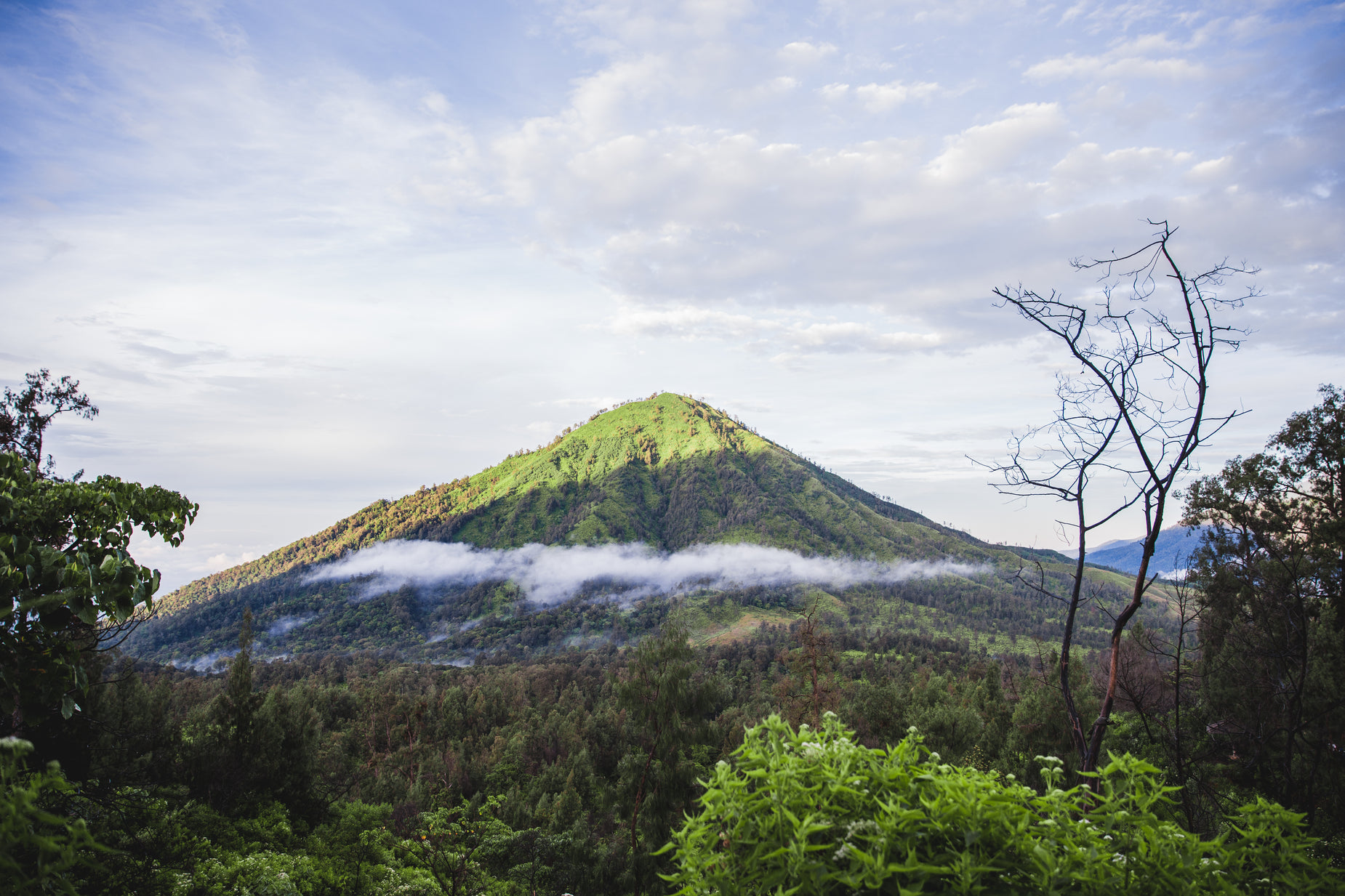 a very tall mountain with lots of clouds in the air