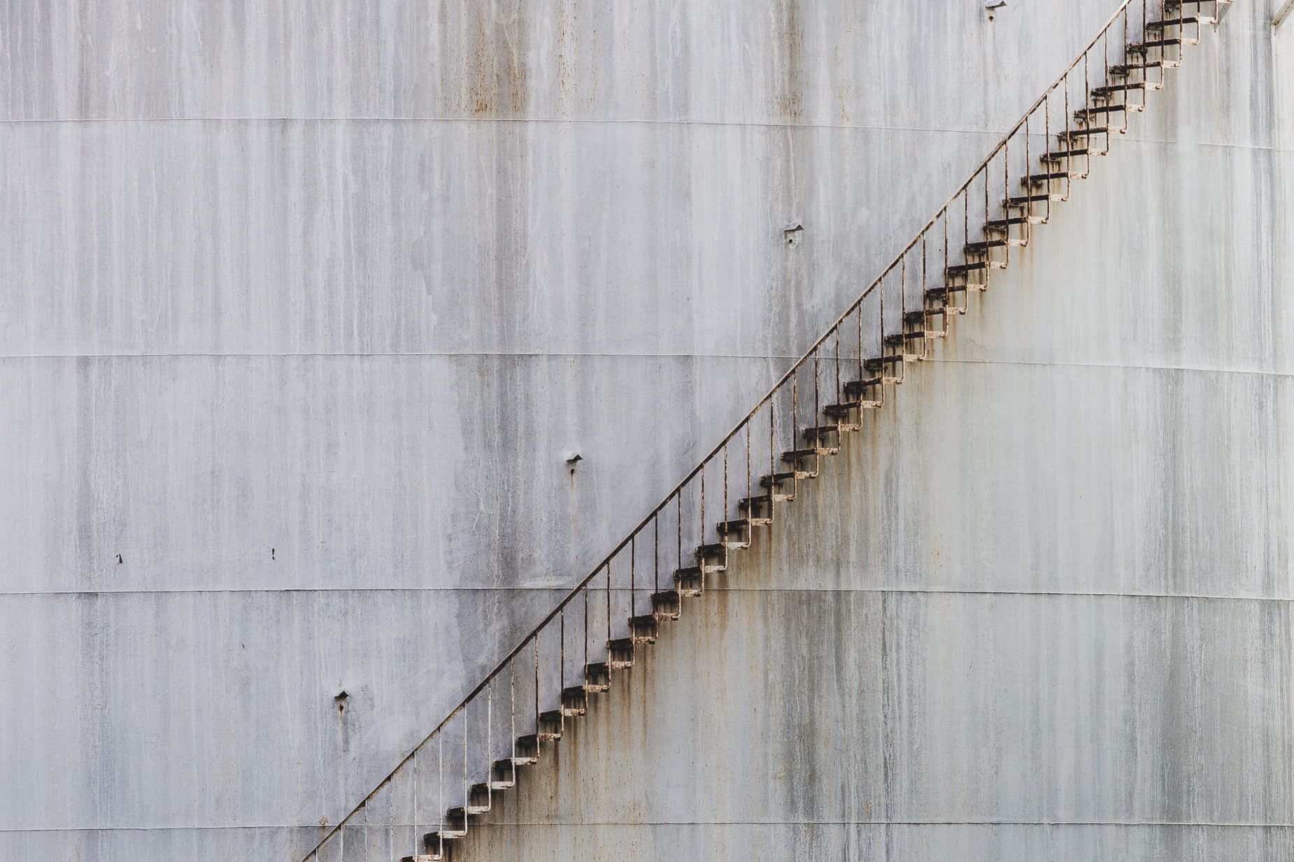 a very long staircase next to a big gray wall