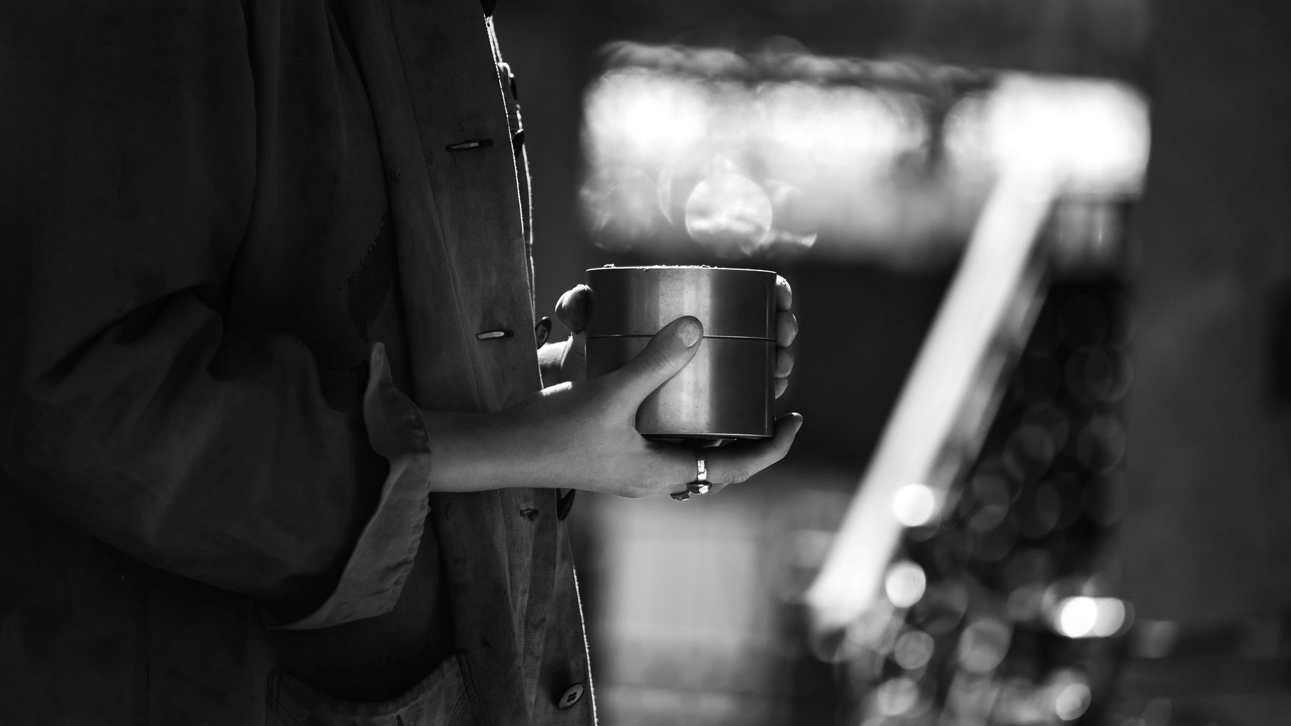 black and white po of a person holding a cup of coffee