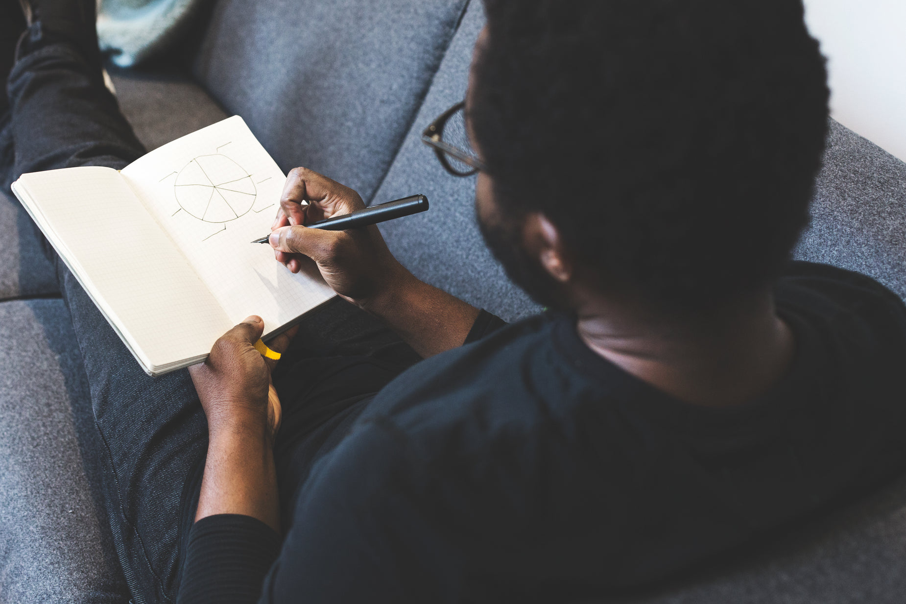 a young man is drawing with a pen