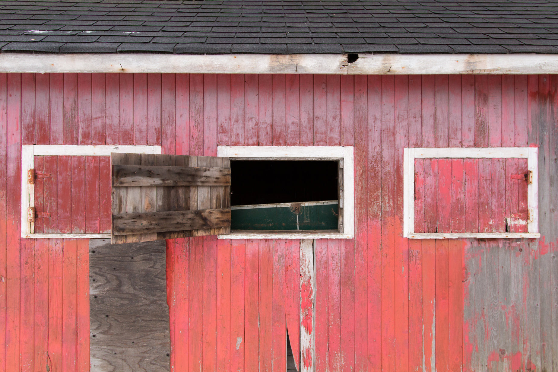 a red barn has two windows on each side