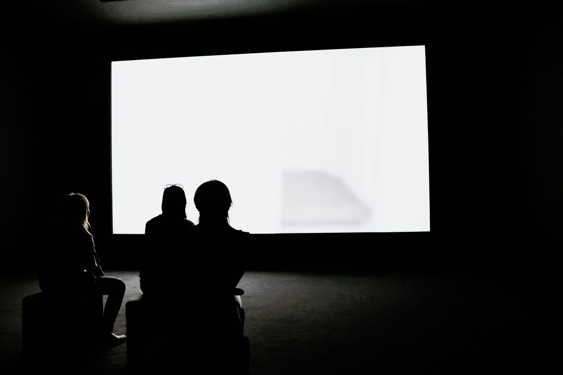 a group of people standing in front of a projection screen