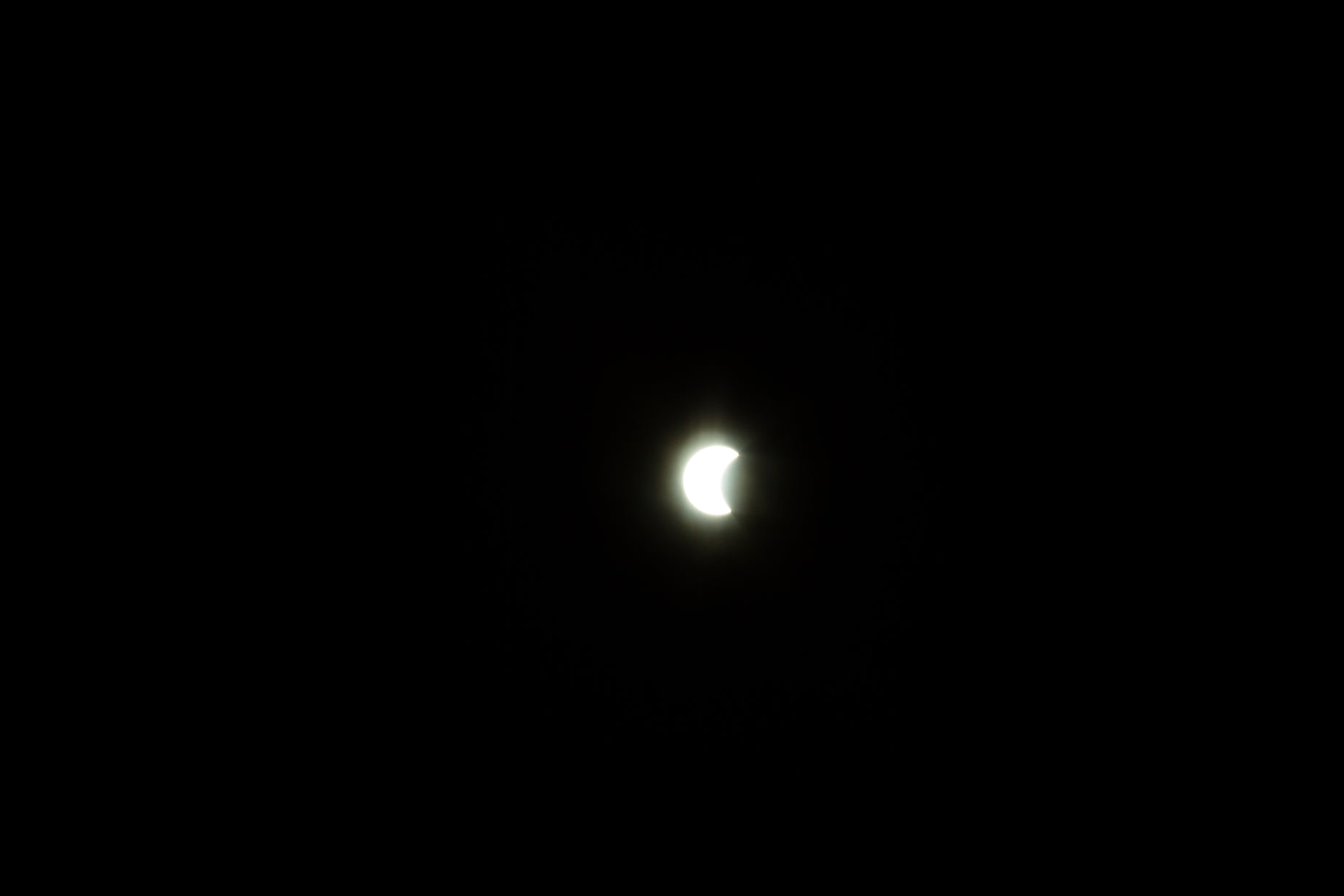 an eclipse in the sky with a bright light at the center