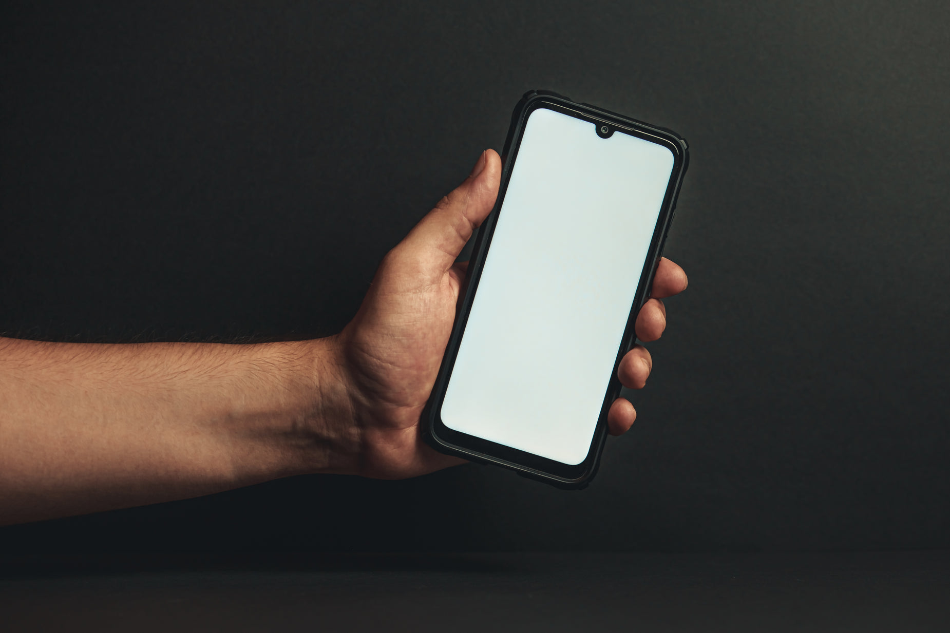 a person holds their cell phone to show the white screen