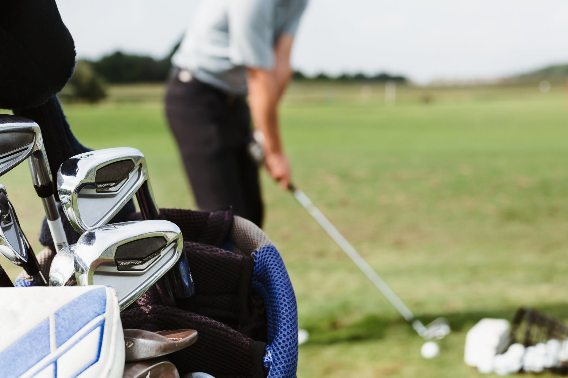 a man standing next to a golf bag filled with club