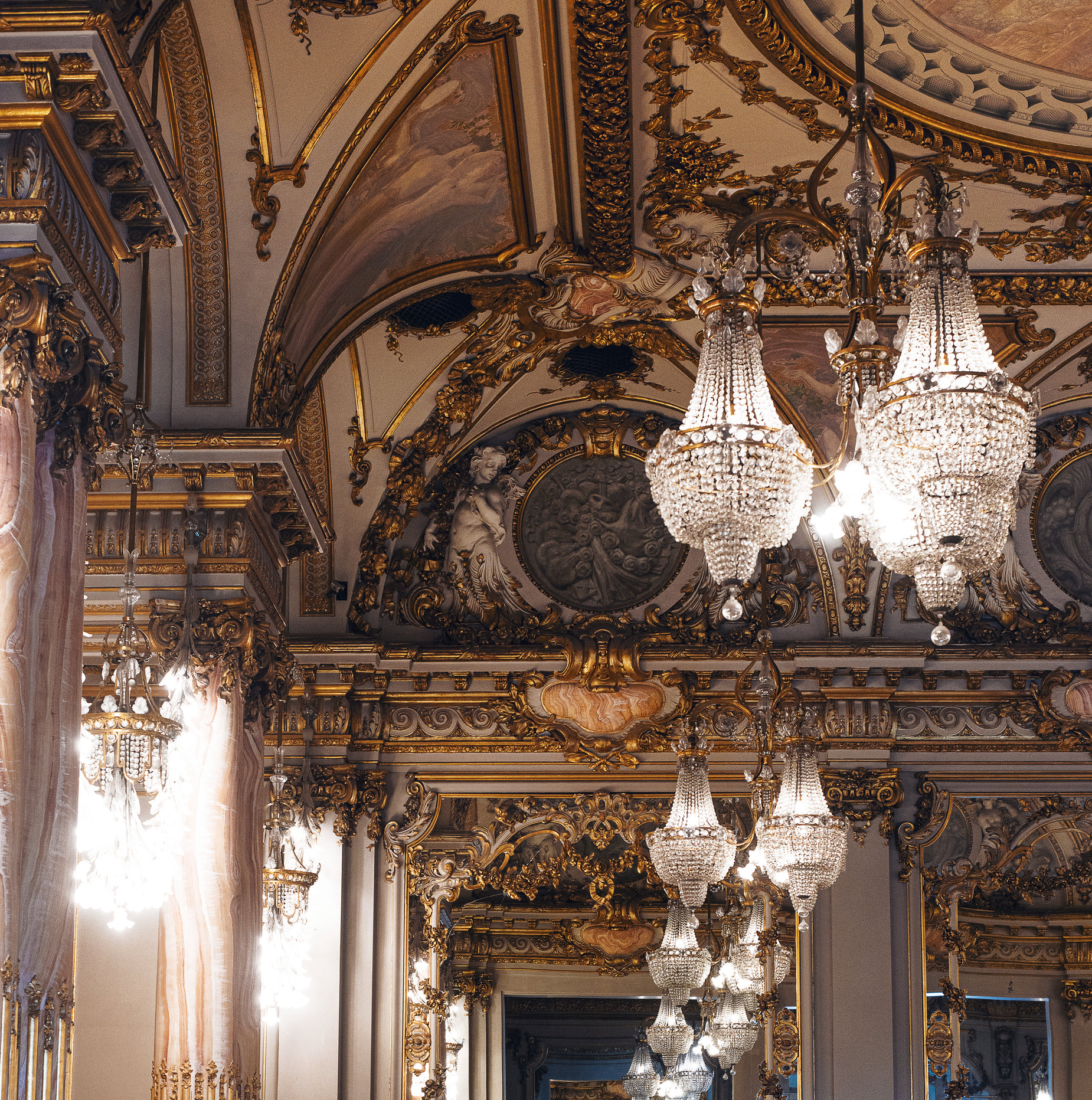 the ornate building has chandeliers hanging from it