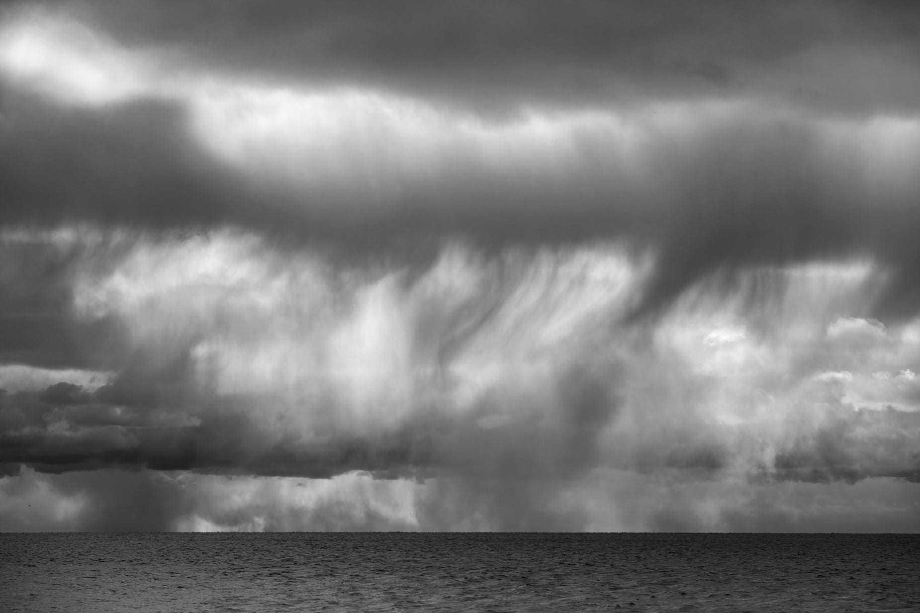 black and white pograph of rain over ocean