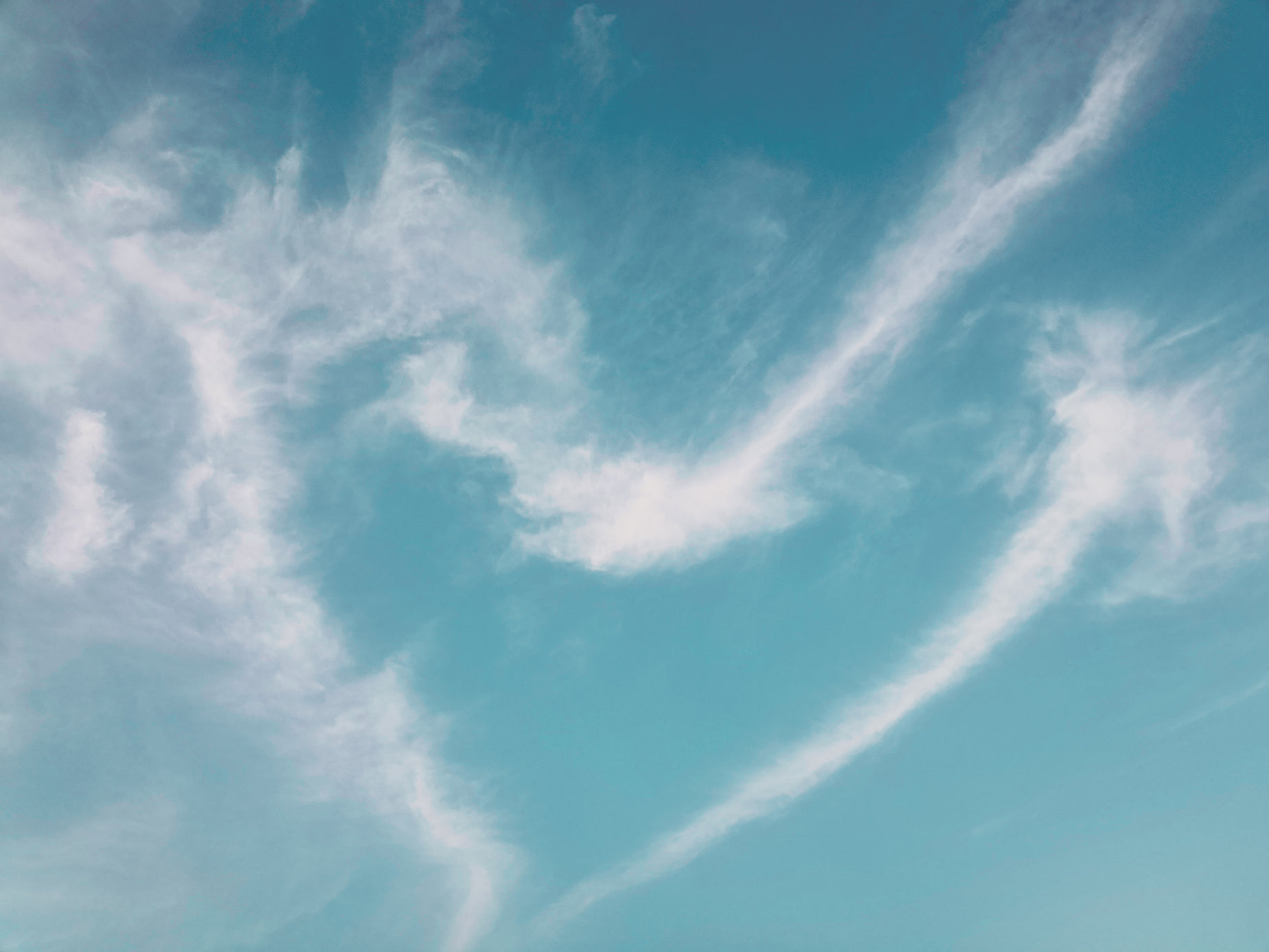 a plane flying in the blue sky filled with white clouds