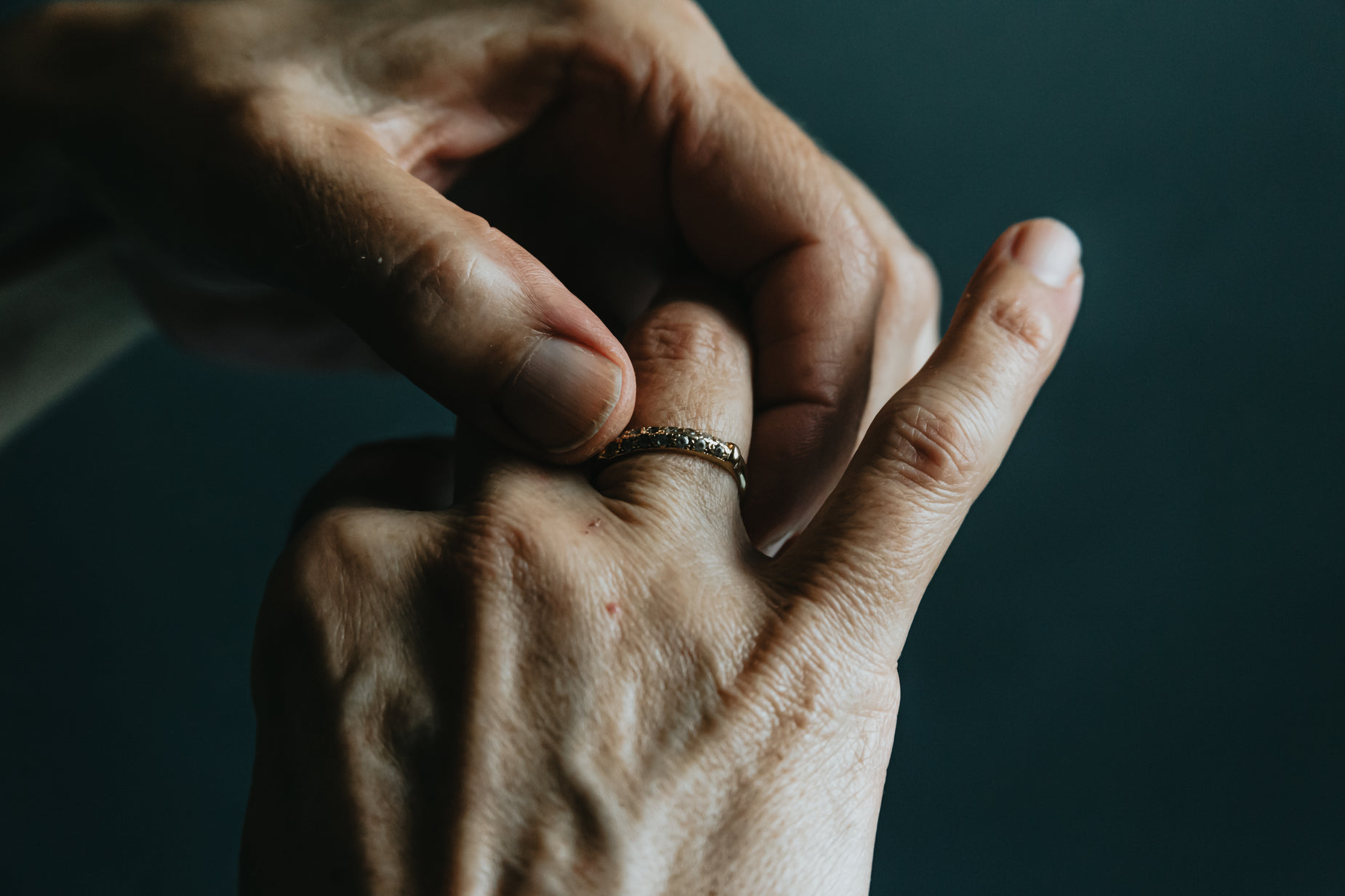 two people holding hands with a ring in the middle