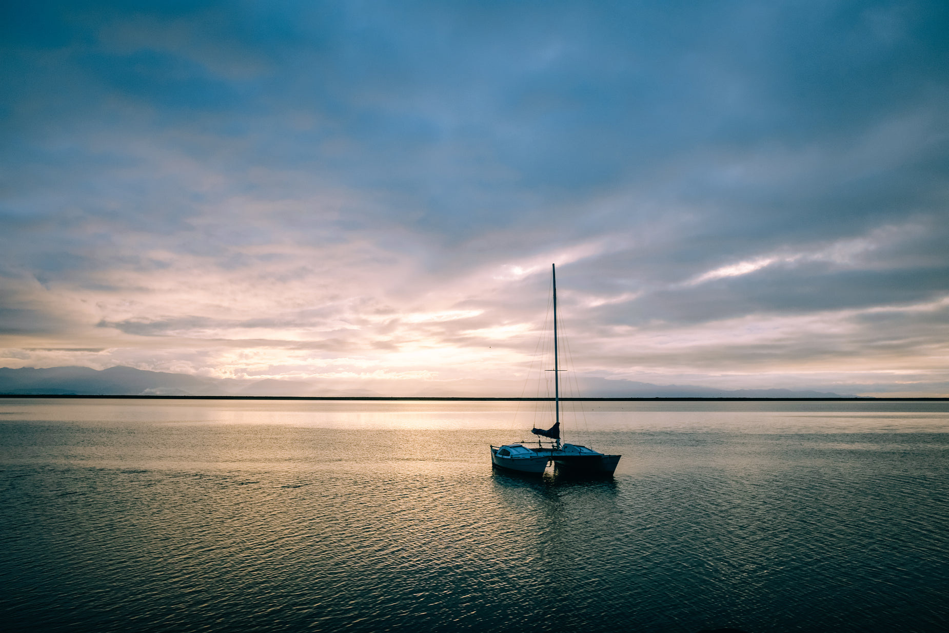 a small boat out on the sea at sunset