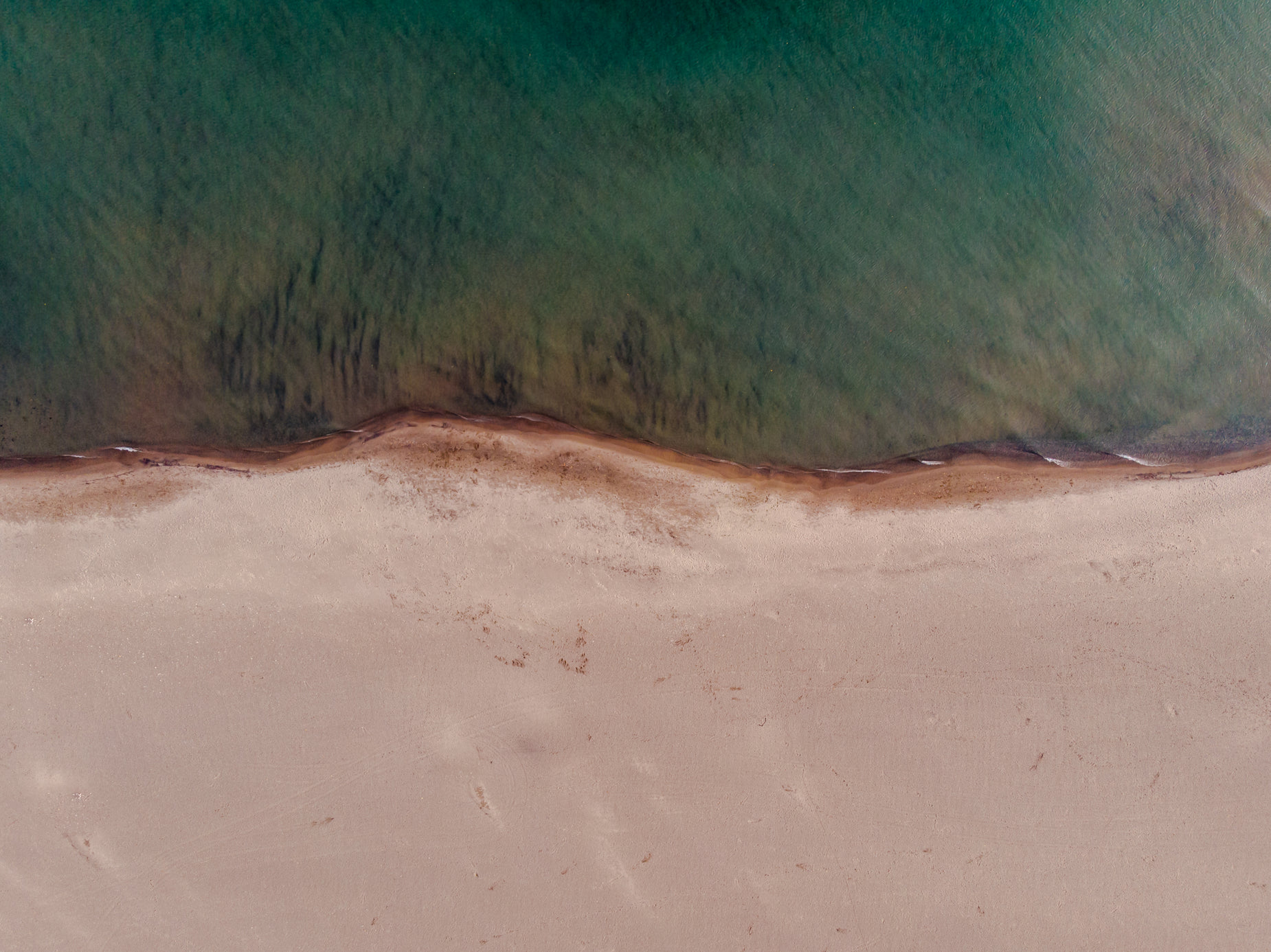 an ocean view of the ocean, with some brown sand