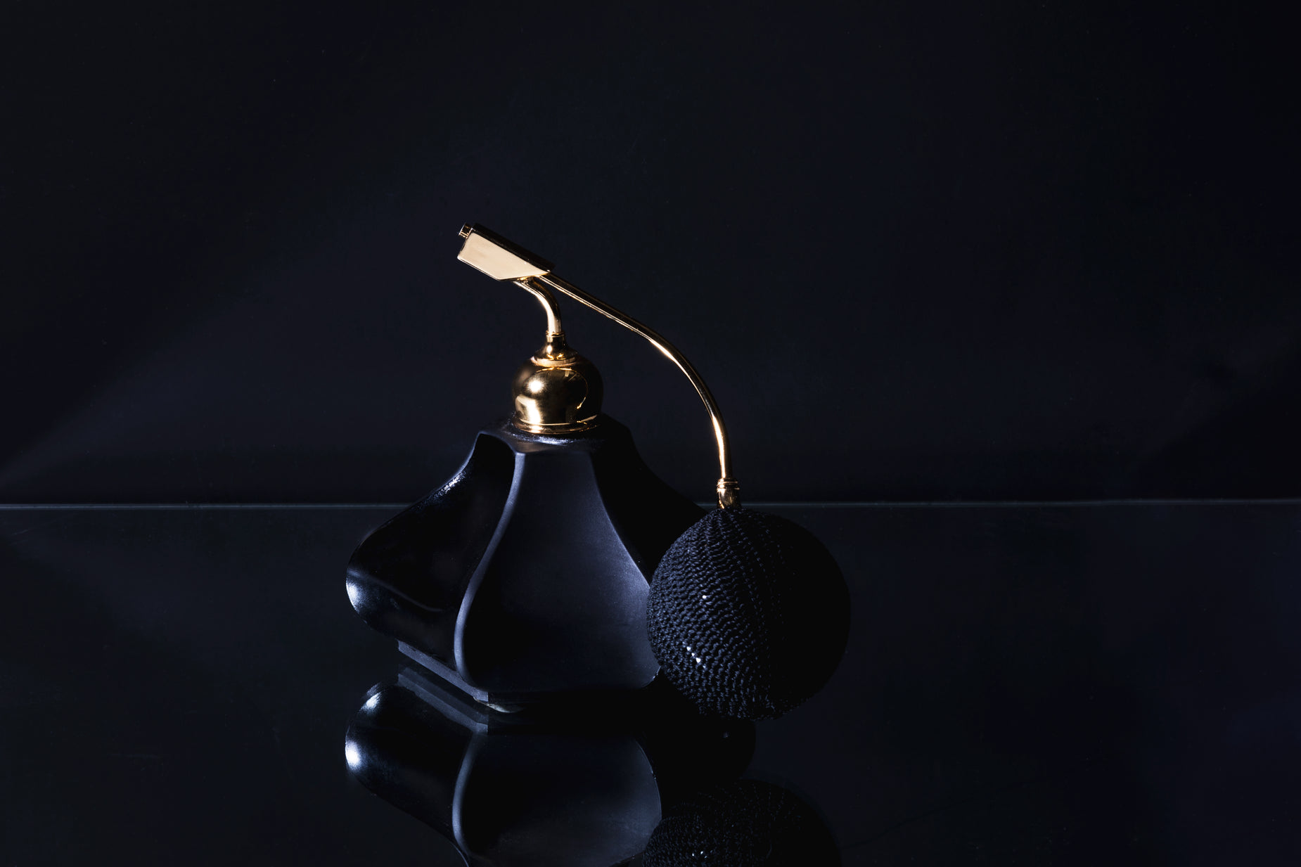 a black vase sitting on top of a reflective table