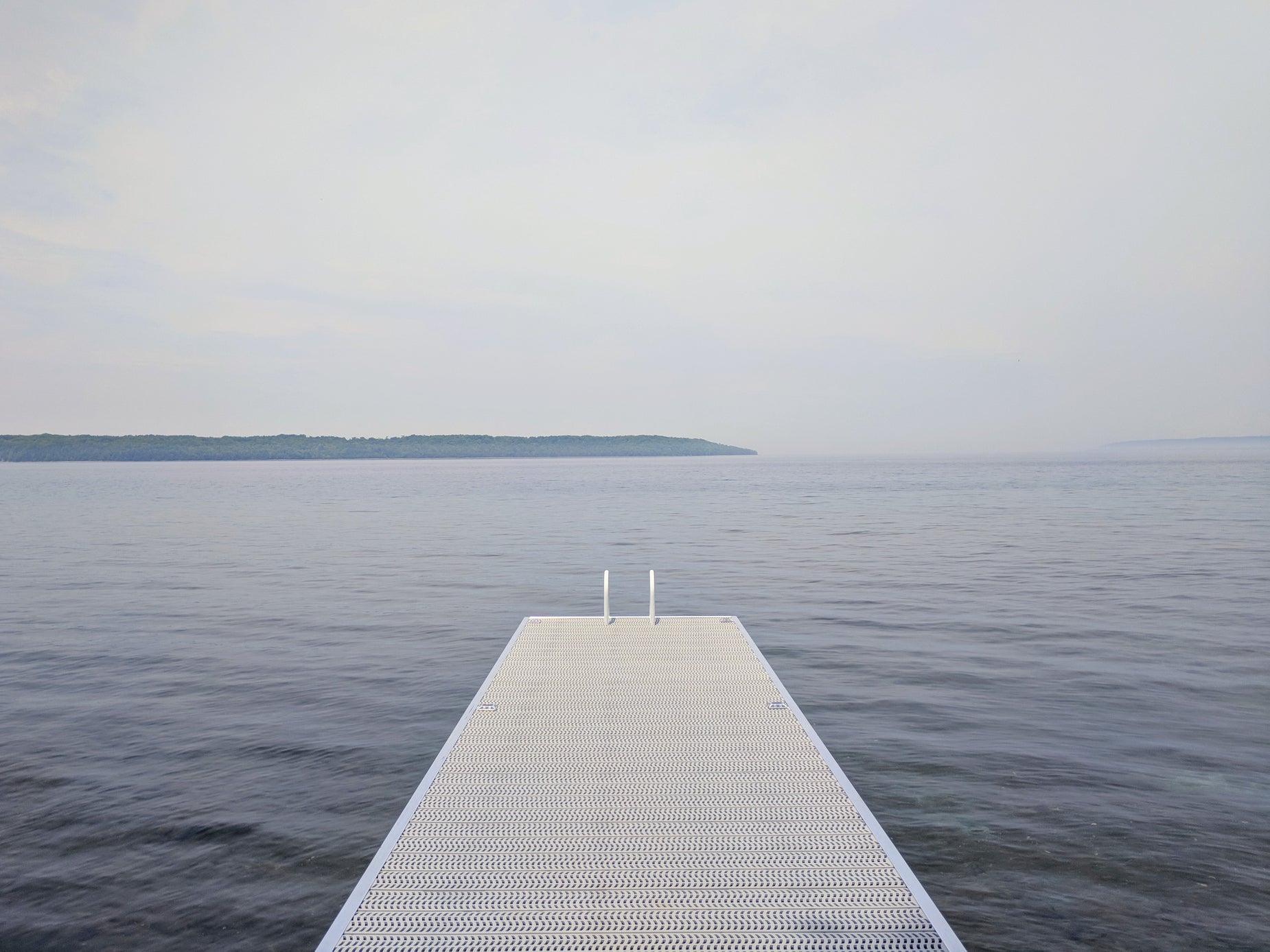 a long dock sitting on the shore of a body of water