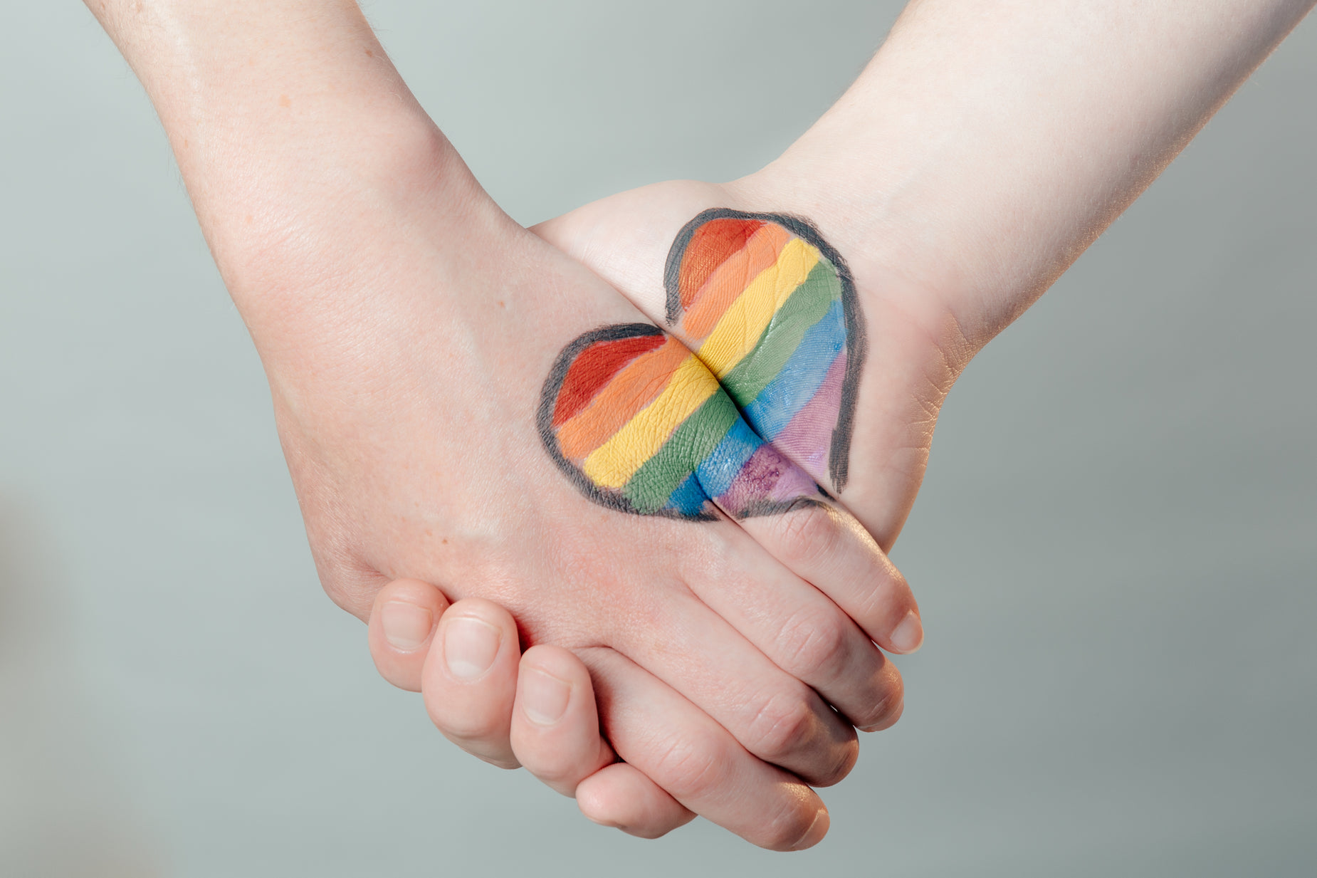 a child and adult holding hands with a heart on it