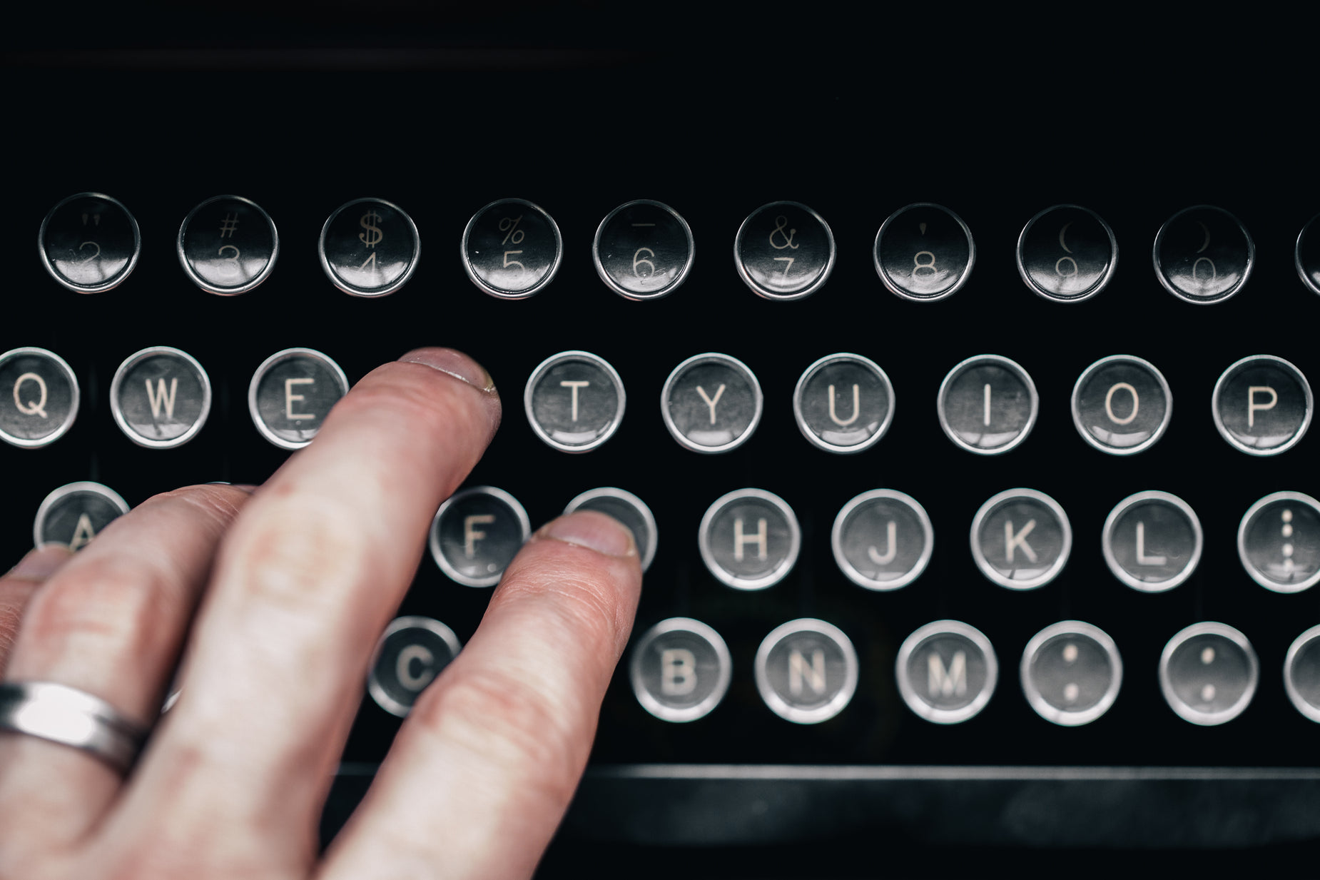 a close up of a person touching the keys on a typewriter