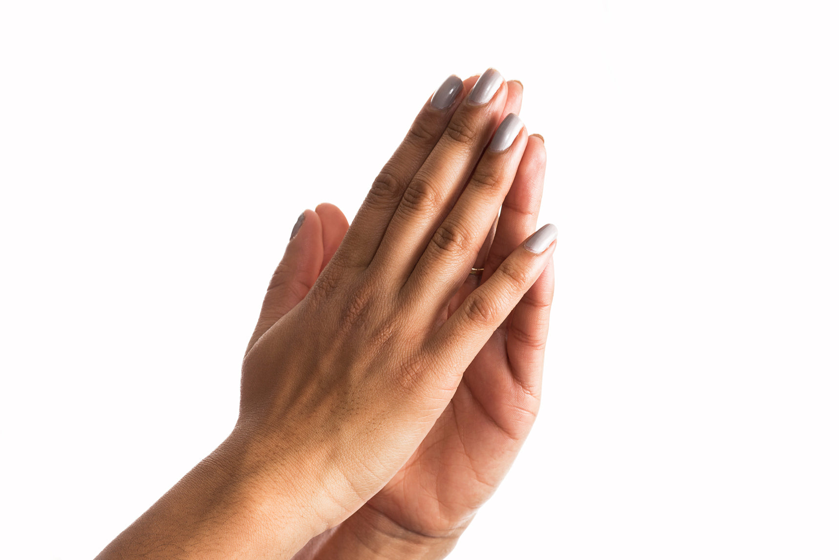 two hands raised in praying position against a white background