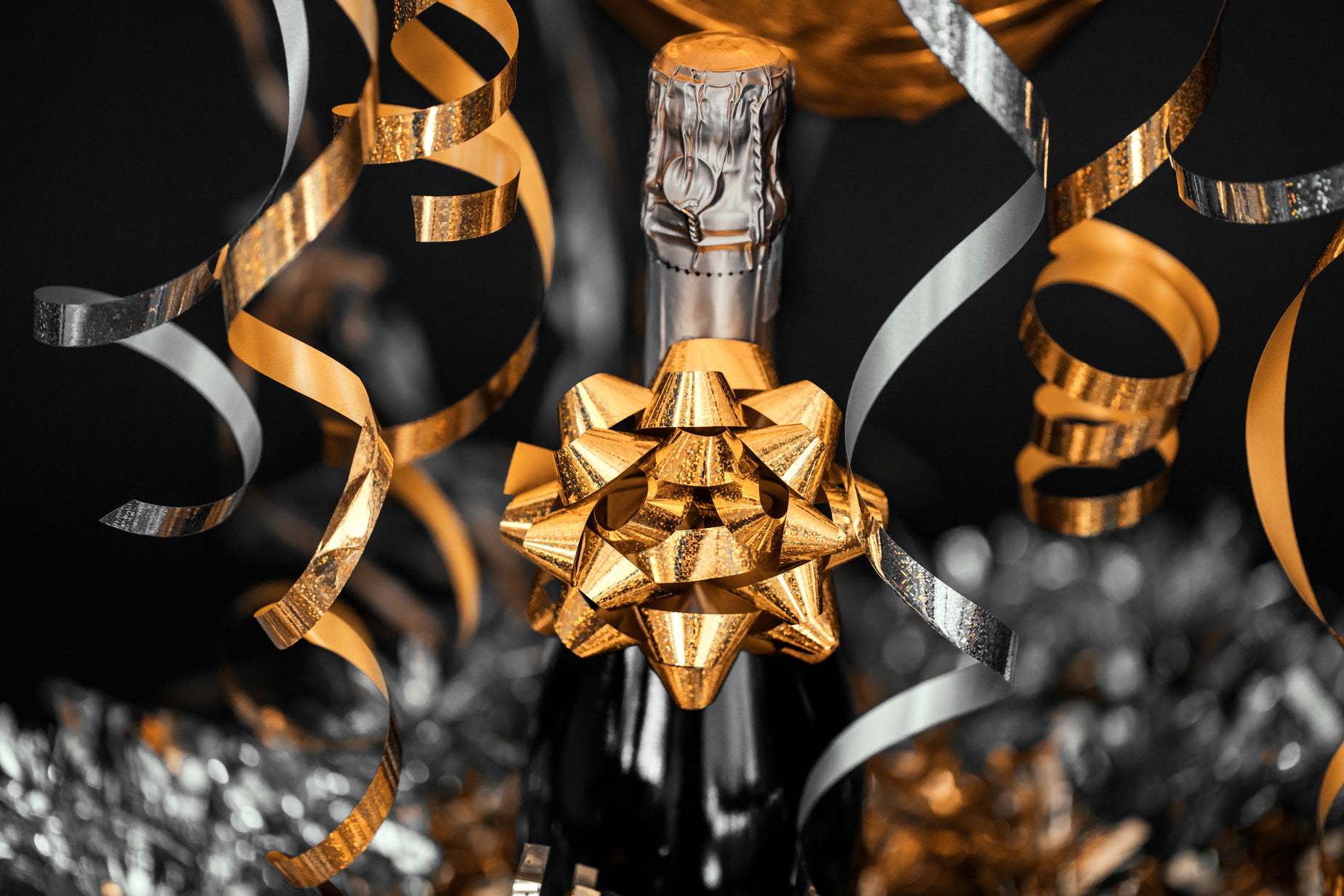 a bottle of wine with gold ribbon on it