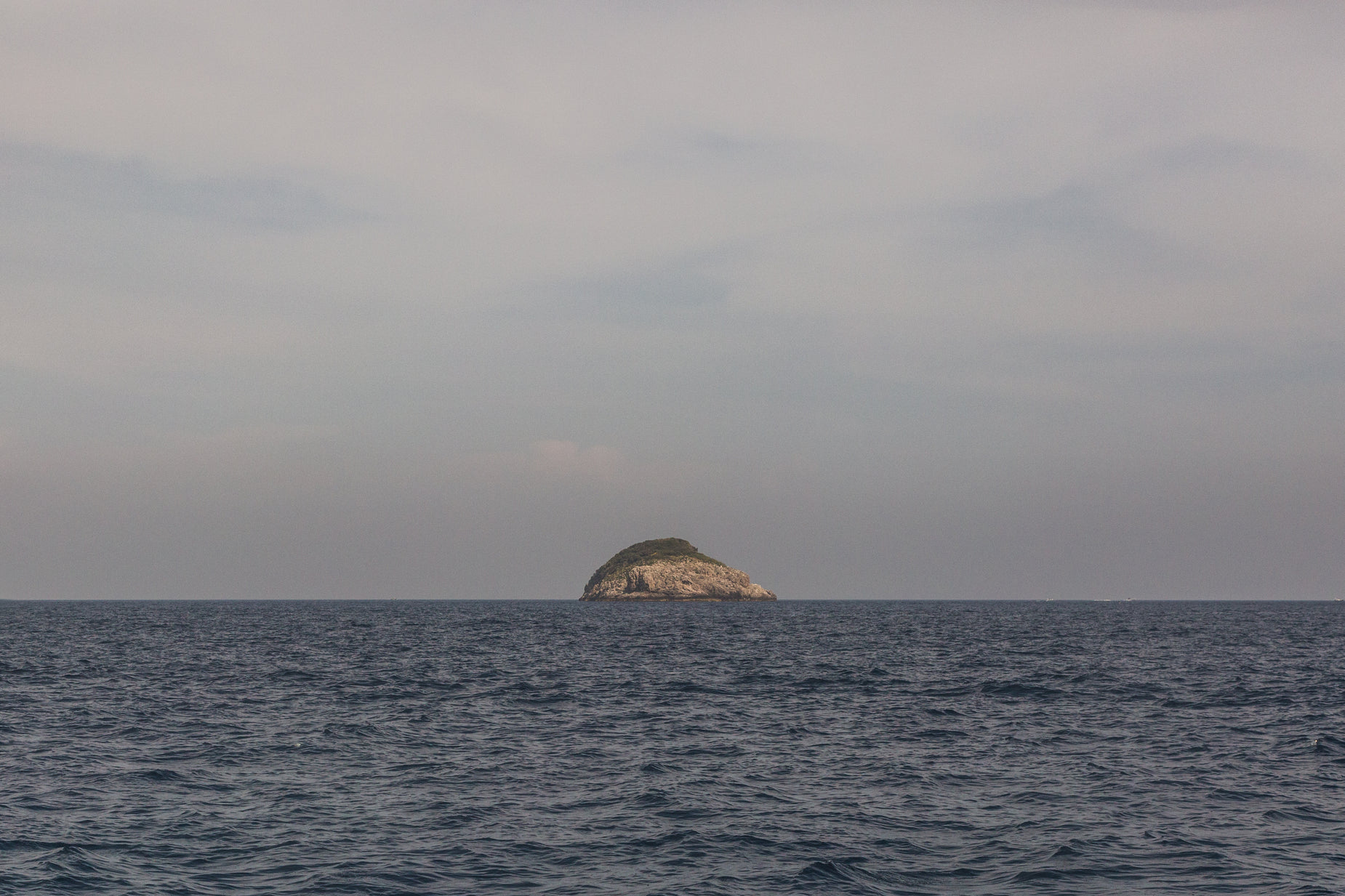 a small island on the ocean with water around it