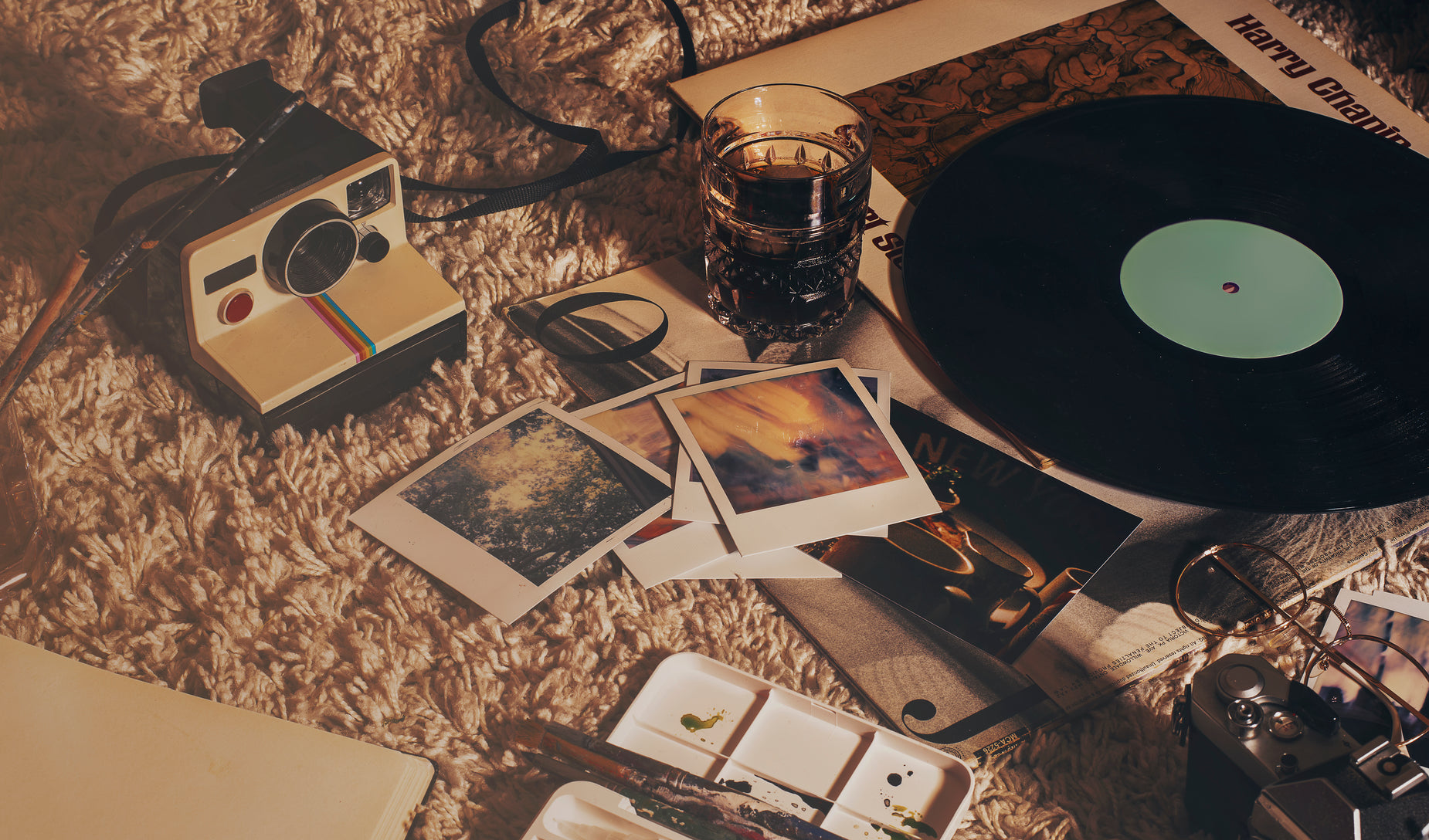 a record player sits on the floor next to several various items
