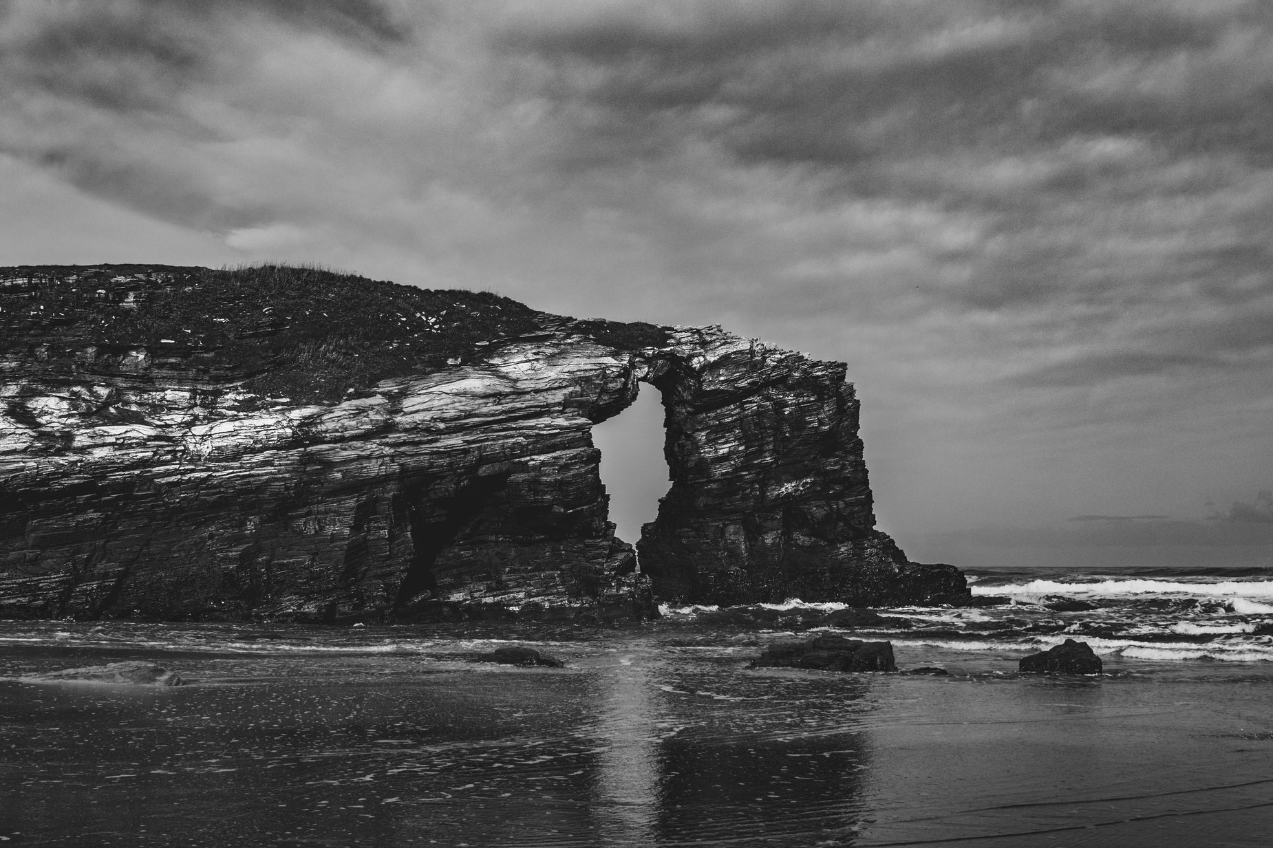 the dark rock formations are a unique feature against the grey sky