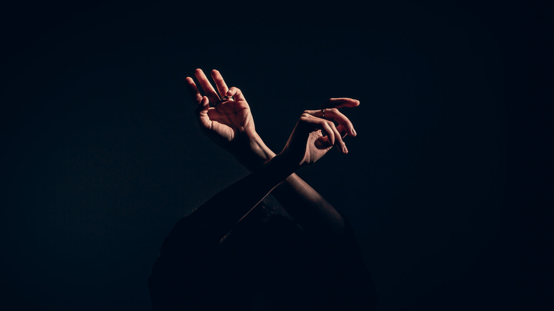 a person's hands are outstretched on a black background