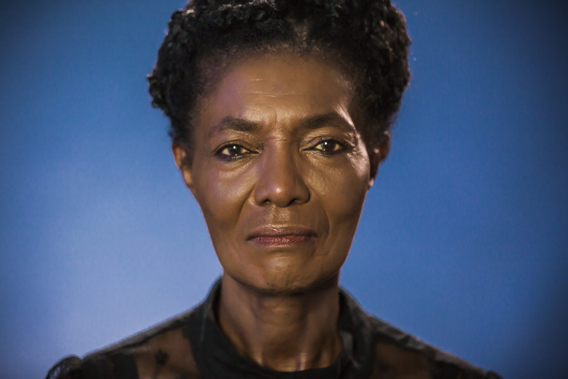 an image of a woman with brown skin and a blue background